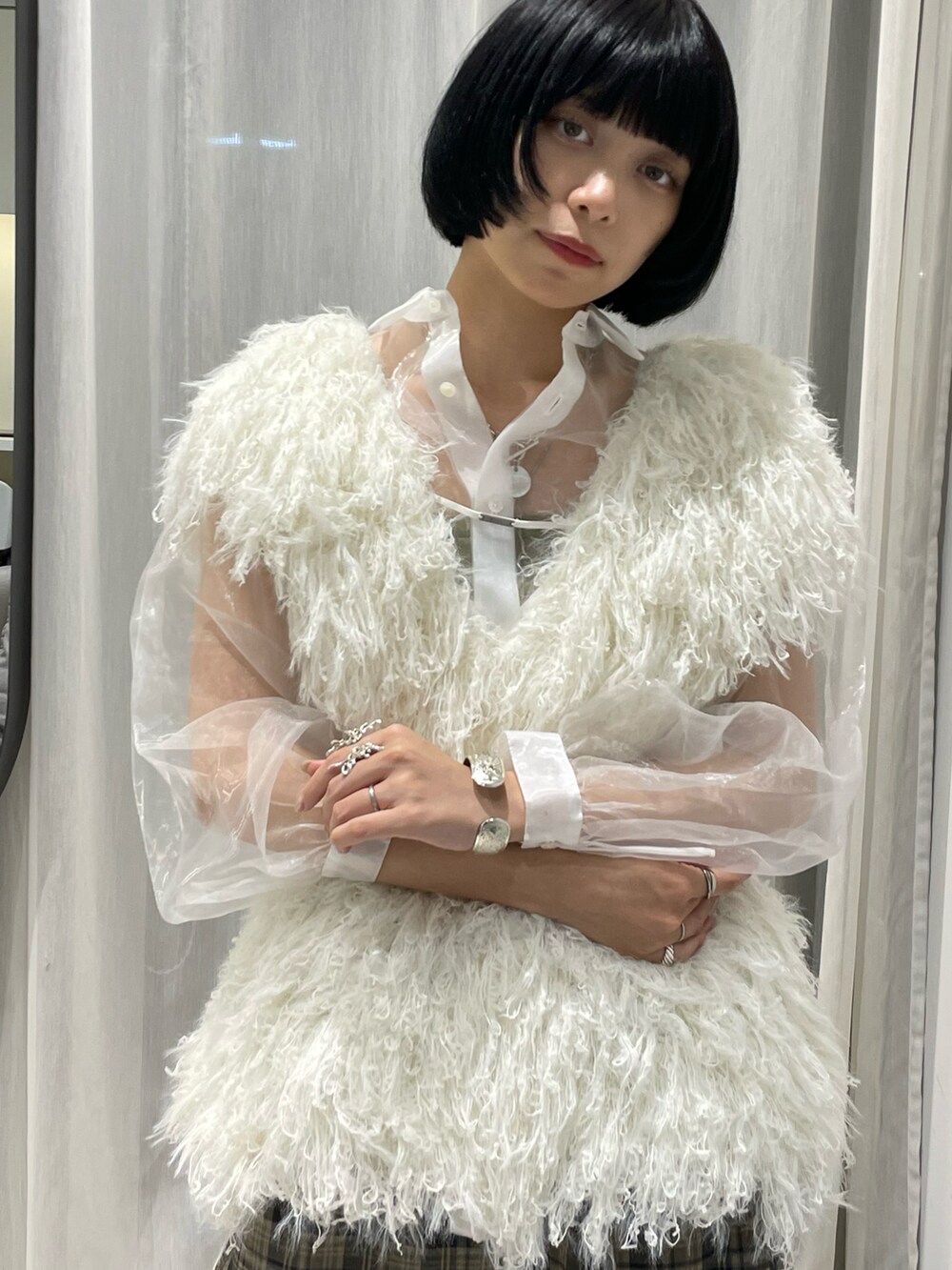 ホワイト系のベスト、ホワイト系のトップス、ブラウン系のパンツを着用したレディースの夏コーディネートの4枚目の写真