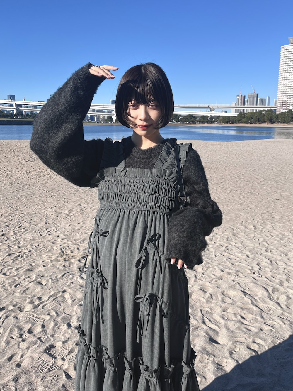 ブラック系のショルダーバッグ、グレー系のワンピース、グレー系のニット/セーターを着用したレディースの冬コーディネートの4枚目の写真