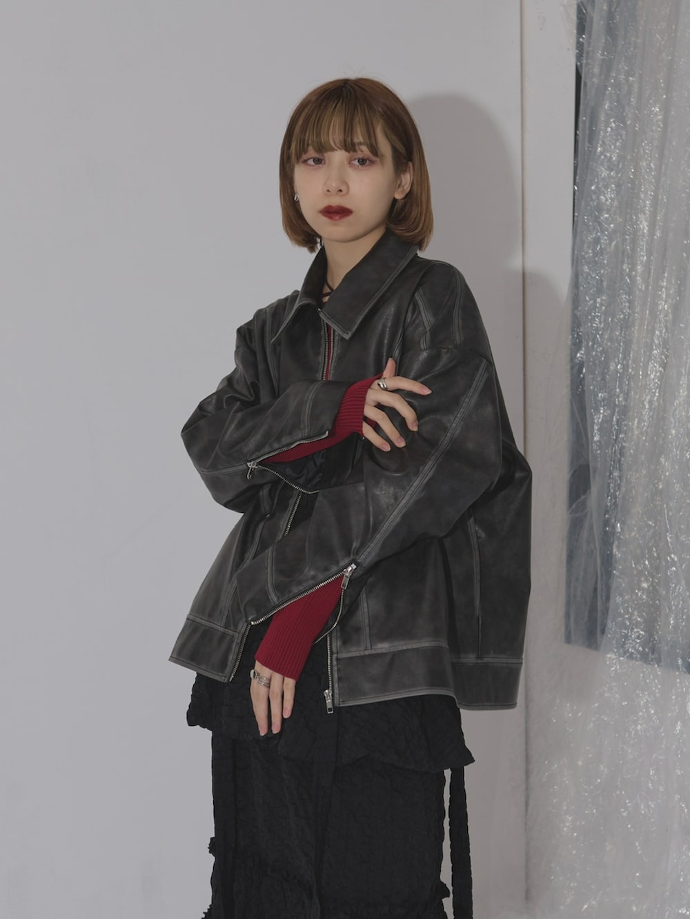 ブラック系のその他アウター、ブラック系のスカート、パープル系のニット/セーターを着用したレディースの冬コーディネートの2枚目の写真