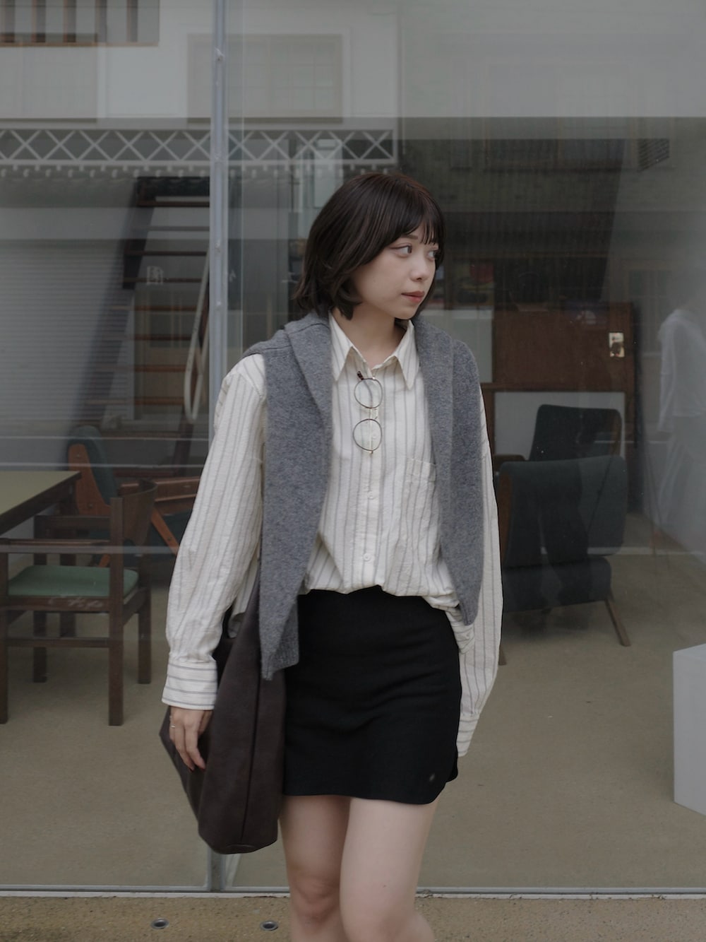 ベージュ系のシャツ/ブラウス、グレー系のニット/セーター、ブラック系のスカートを着用したレディースの秋コーディネートの2枚目の写真