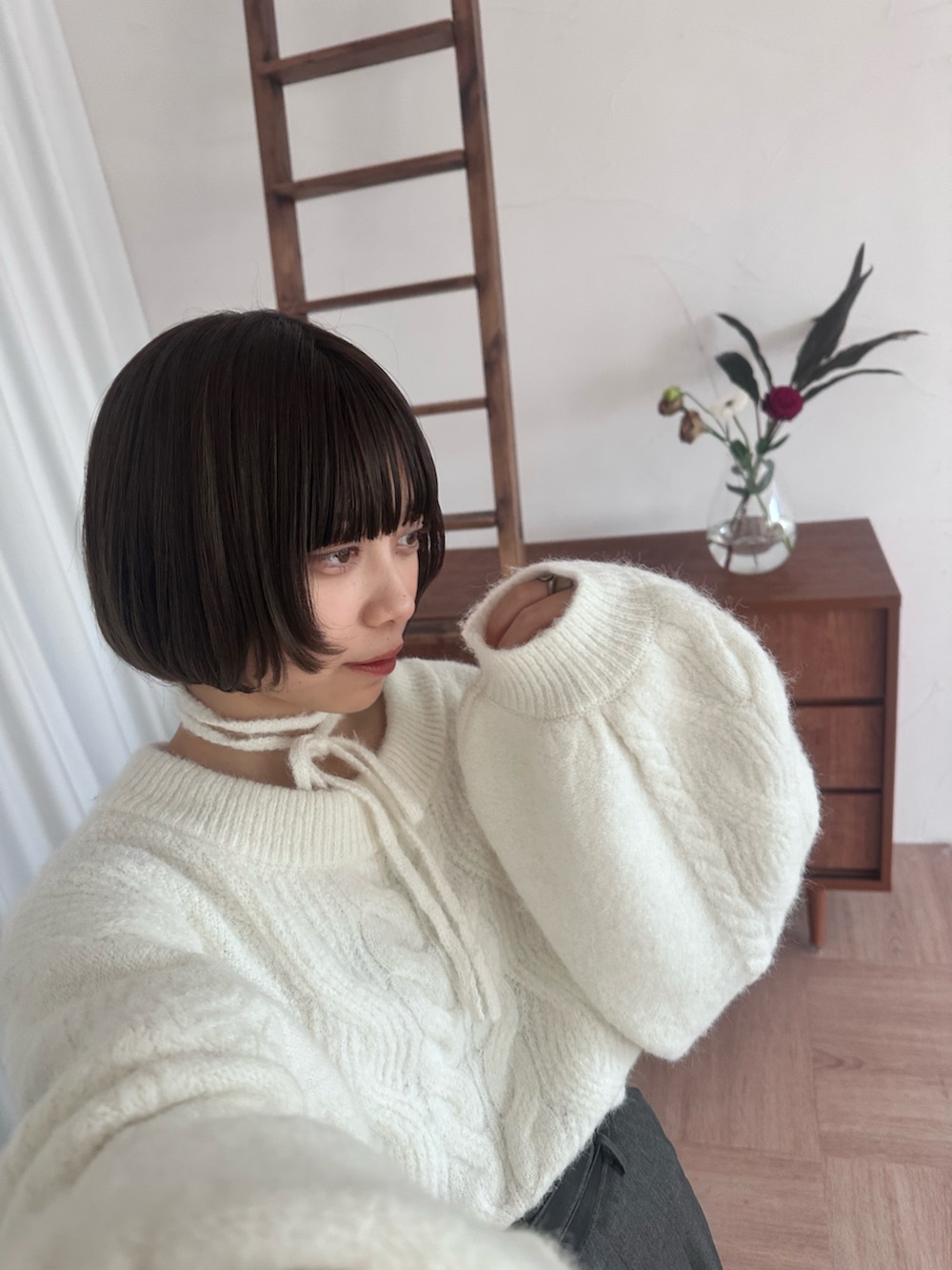 グレー系のスカート、シルバー系のブーツ、ホワイト系のニット/セーターを着用したレディースの冬コーディネートの3枚目の写真