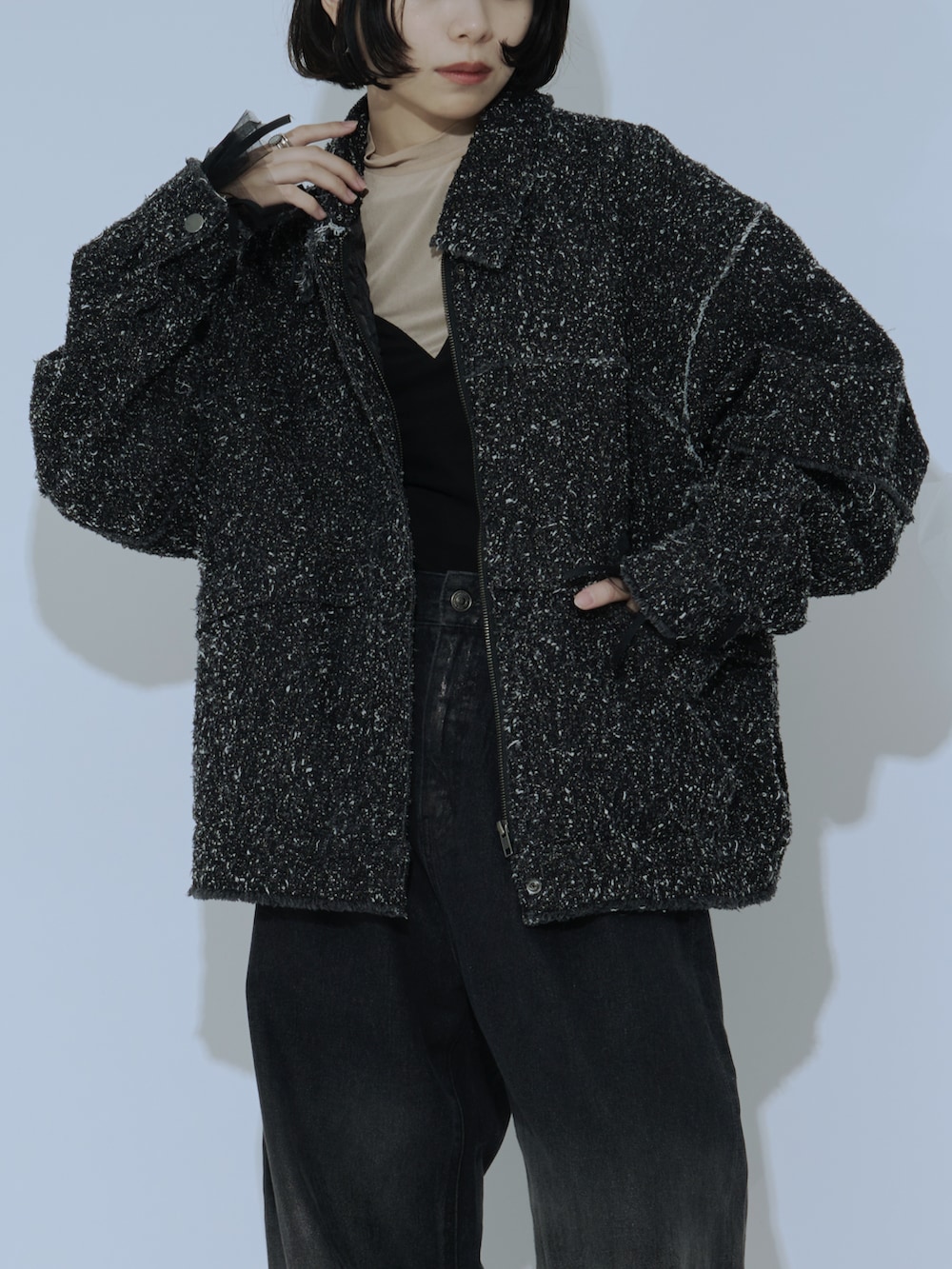 ブラック系のデニムパンツ、ブラック系のブーツを着用したレディースの冬コーディネートの2枚目の写真