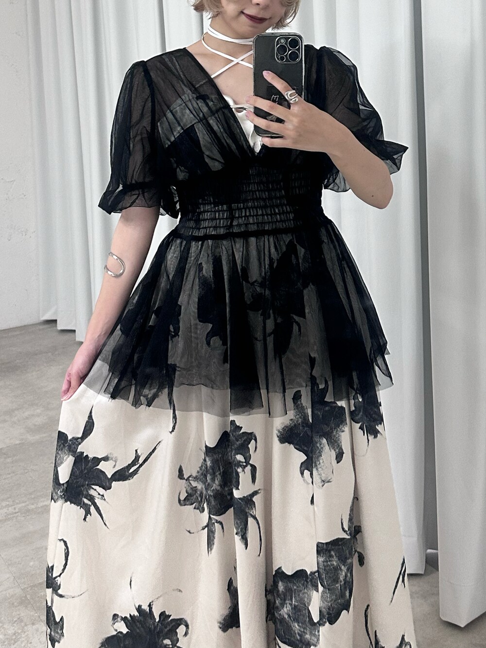 ホワイト系のワンピース、ブラック系のパンプス、ブラック系のトップスを着用したレディースの春コーディネートの2枚目の写真