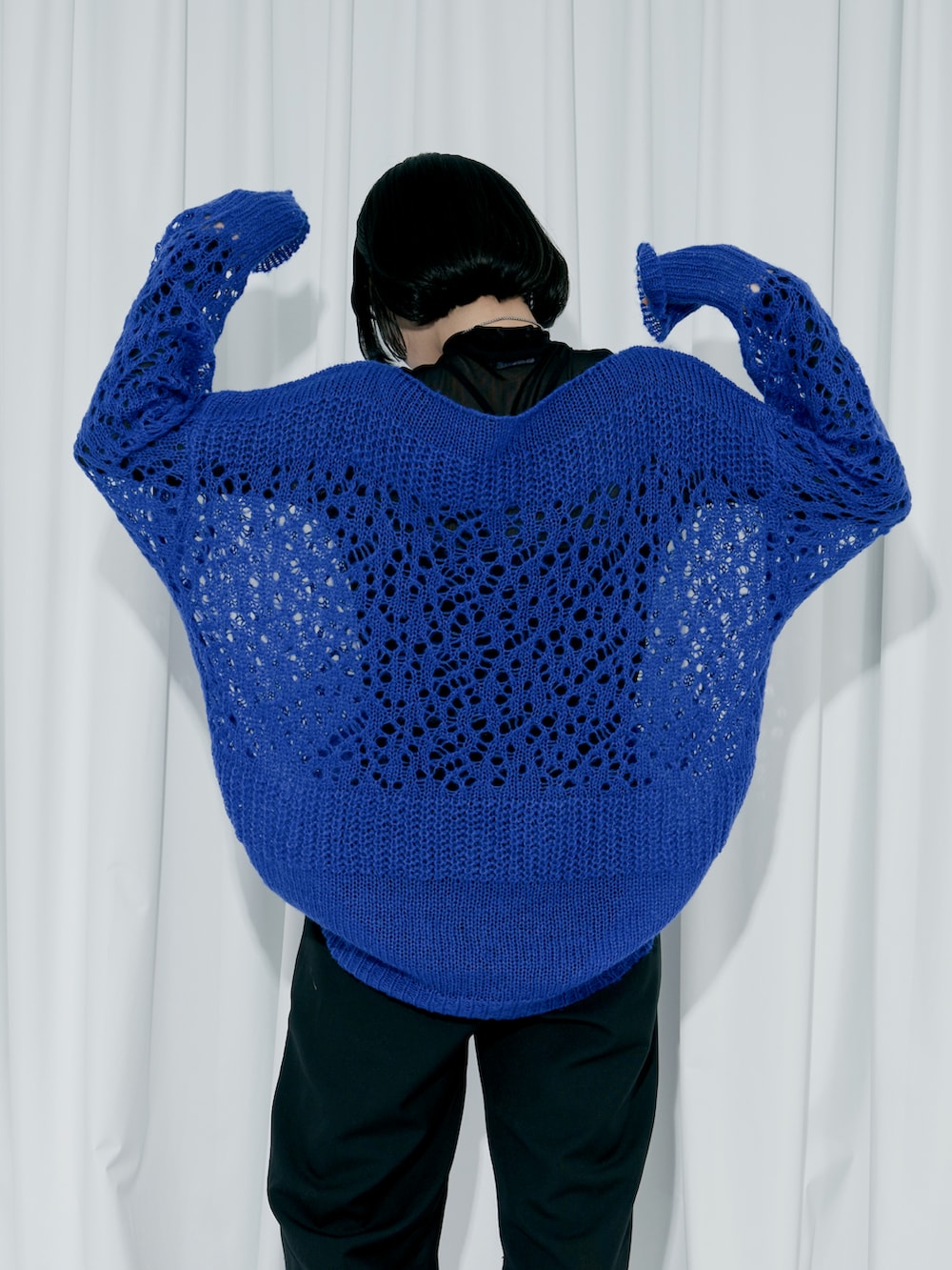 ブルー系のニット/セーター、ブラック系のスラックス、ブラック系のパンプスを着用したレディースの冬コーディネートの3枚目の写真