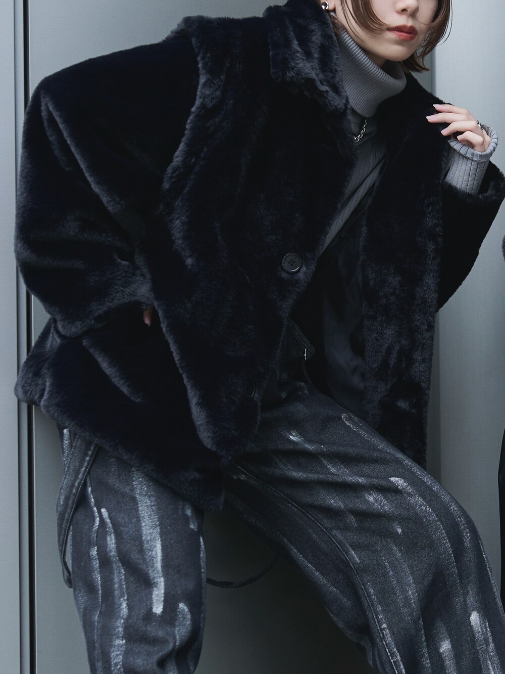 ブラック系のブルゾン、グレー系のニット/セーター、ブラック系のデニムパンツを着用したレディースの冬コーディネートの3枚目の写真