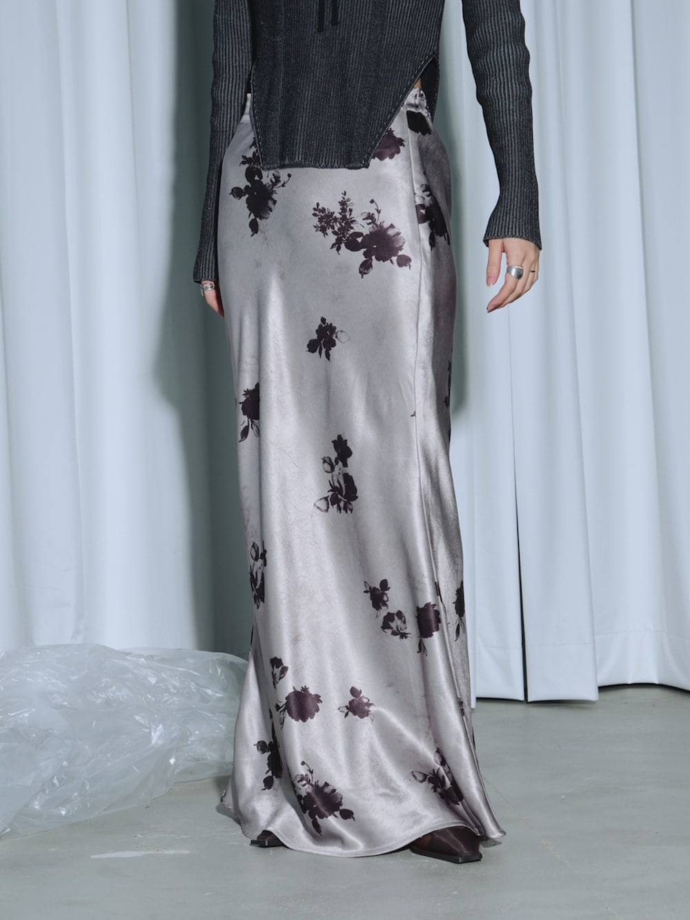 ブラック系のテーラードジャケット、パープル系のニット/セーター、パープル系のスカートを着用したレディースの春コーディネートの3枚目の写真