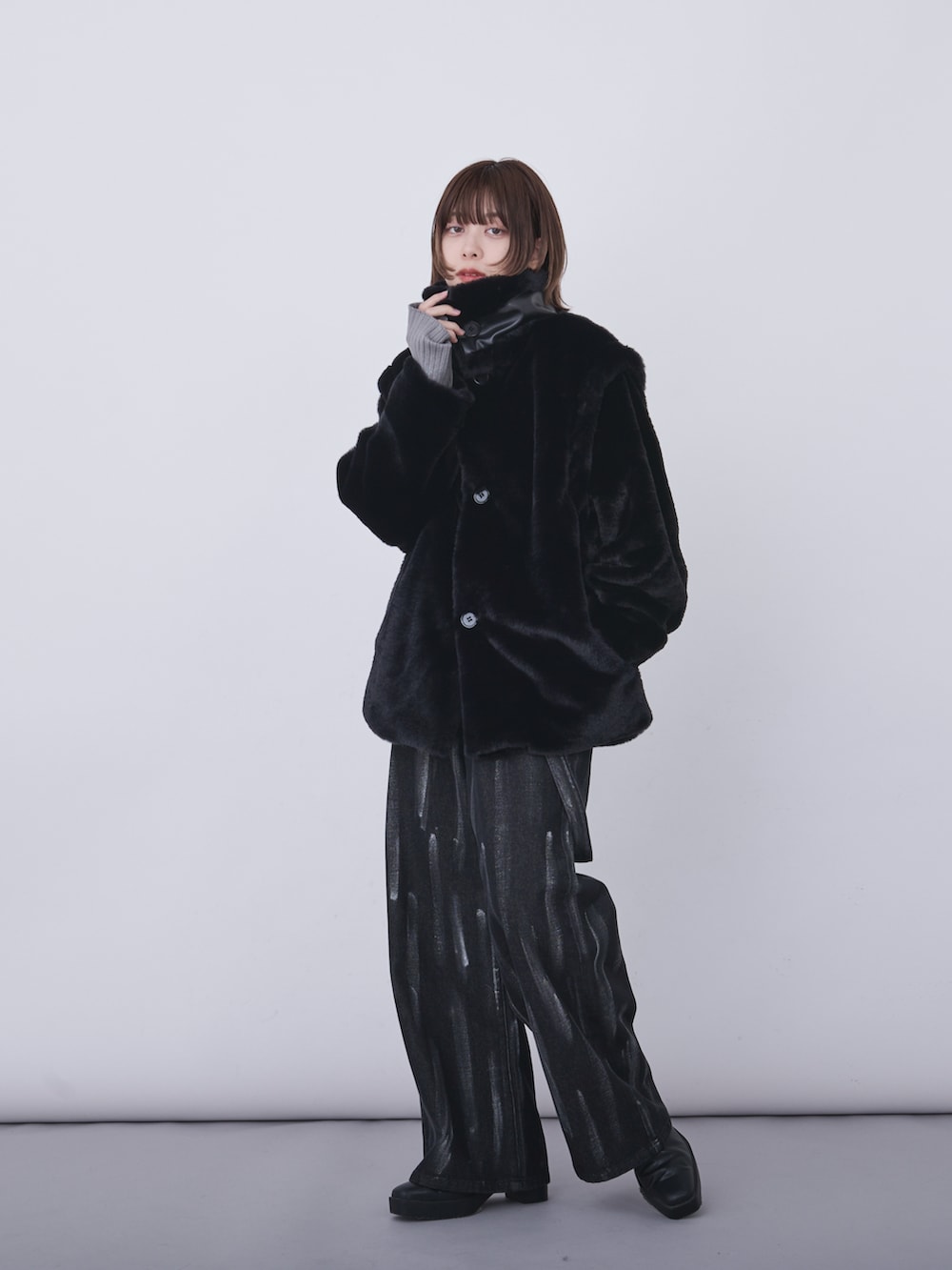 ブラック系のブルゾン、グレー系のニット/セーター、ブラック系のデニムパンツを着用したレディースの冬コーディネートの3枚目の写真