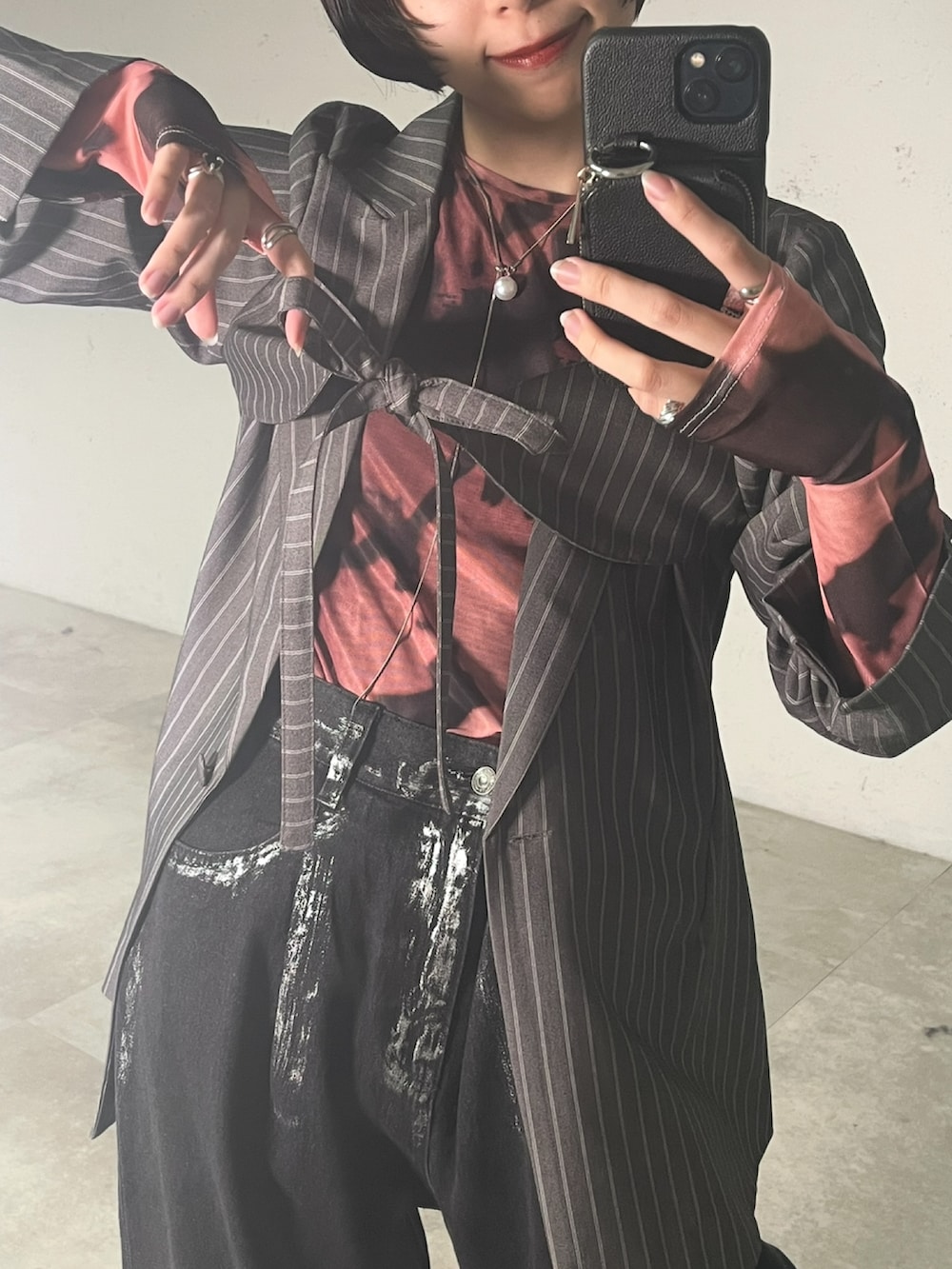 グレー系のテーラードジャケット、ピンク系のTシャツ/カットソー、ブラック系のデニムパンツを着用したレディースの春コーディネートの2枚目の写真