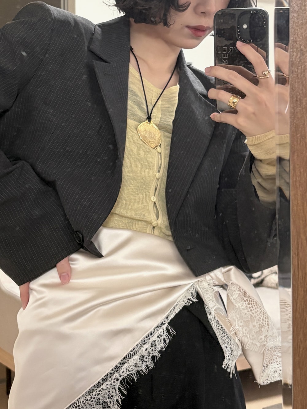 イエロー系のトップス、グレー系のジャケット/アウター、ブラック系のパンツを着用したレディースの春コーディネートの3枚目の写真