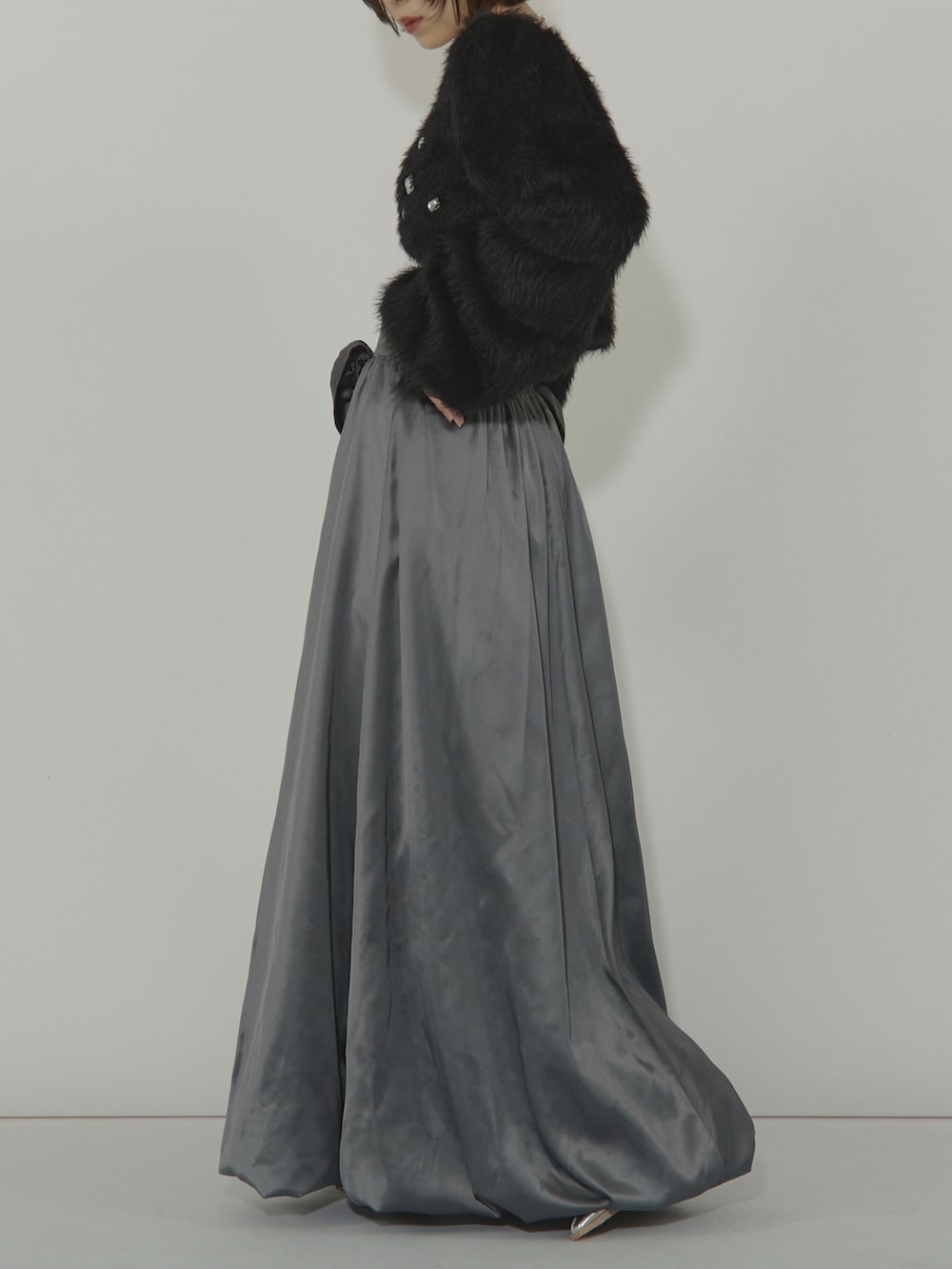 ブラック系のカーディガン/ボレロ、グレー系のスカートを着用したレディースの冬コーディネートの3枚目の写真