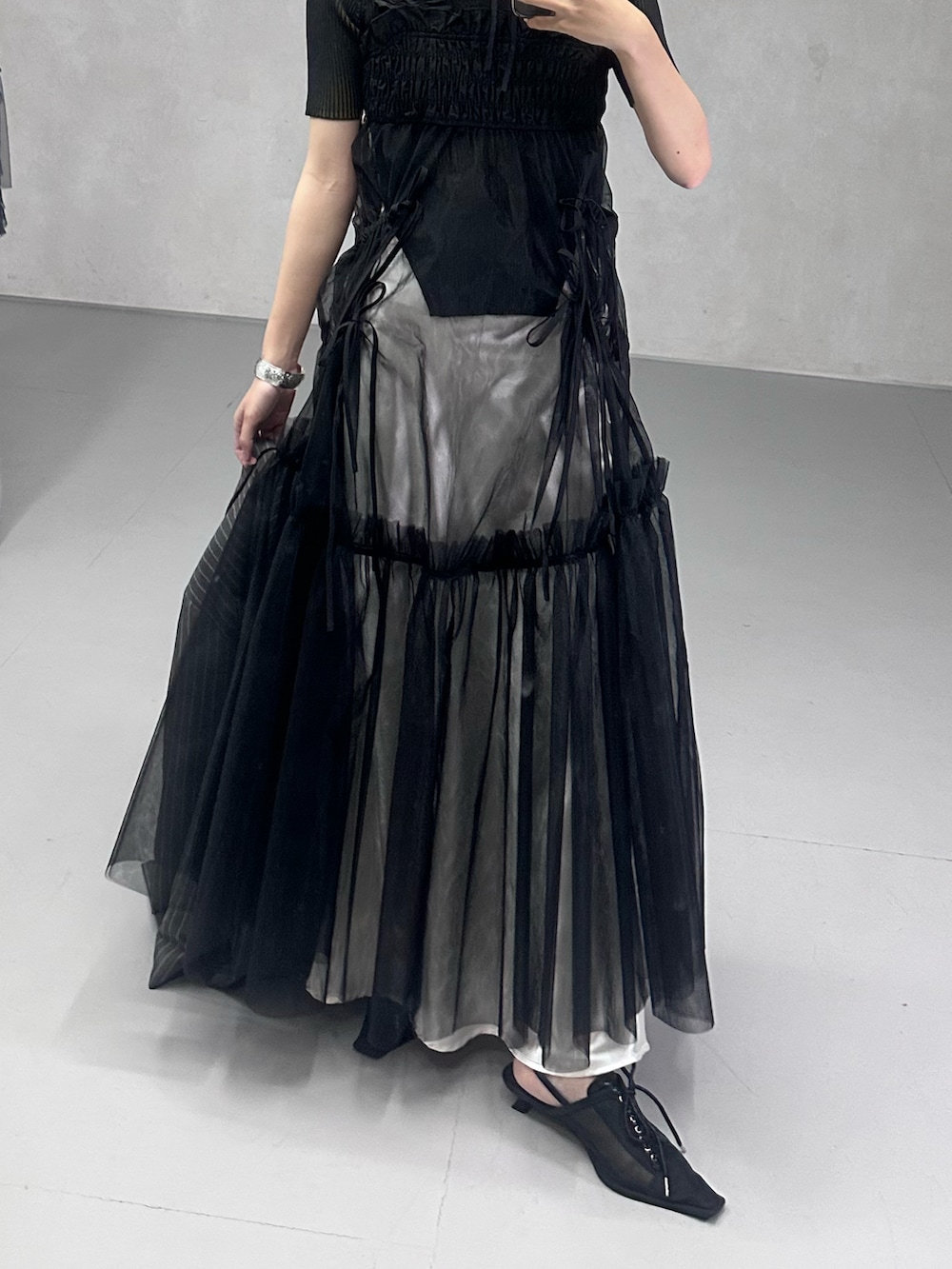 ブラック系のワンピース、ブラック系のパンプス、ブルー系のニット/セーターを着用したレディースの春コーディネートの2枚目の写真