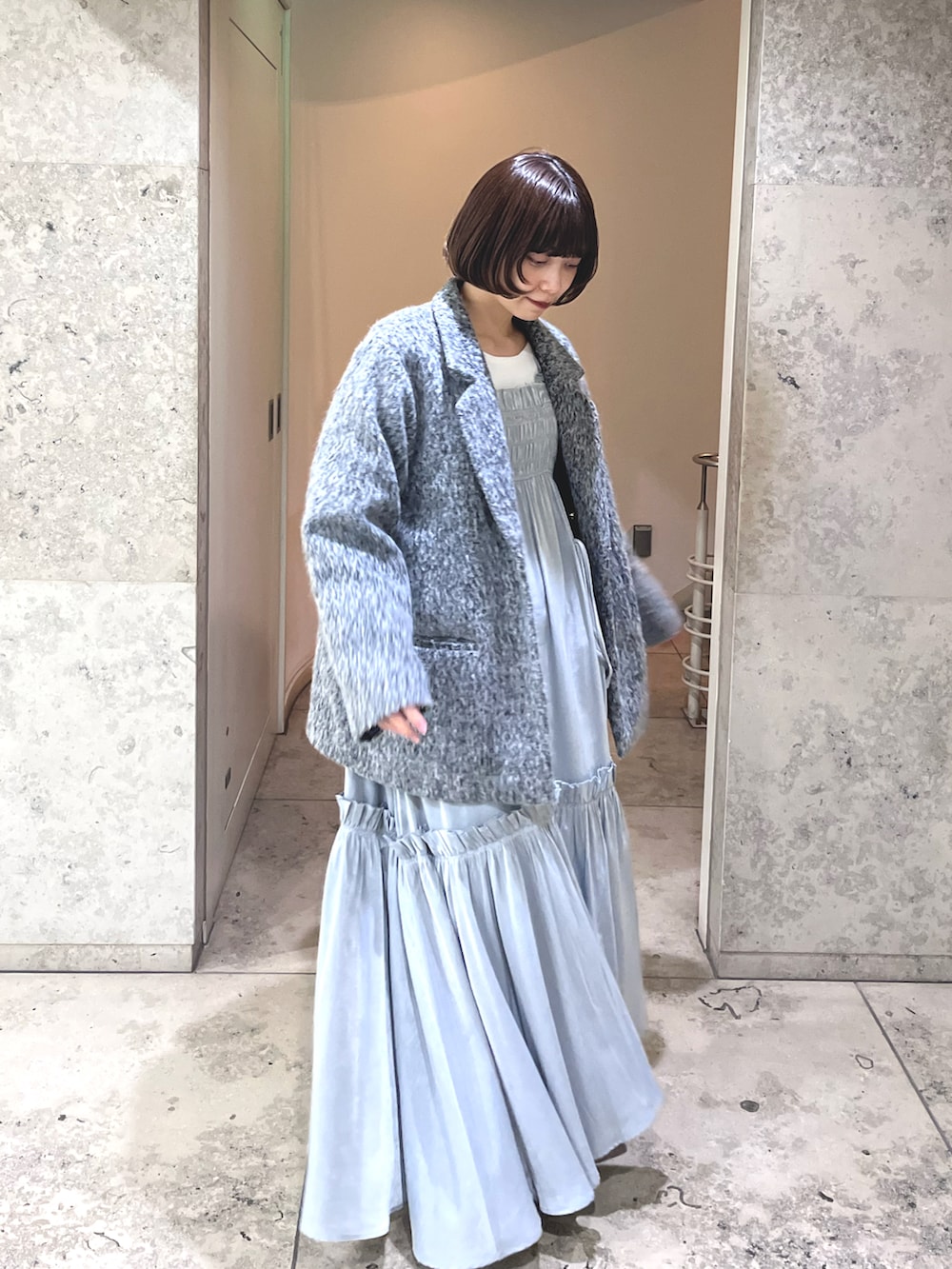 グレー系のテーラードジャケット、ブラック系のワンピース、ブラック系のショルダーバッグを着用したレディースの冬コーディネートの2枚目の写真