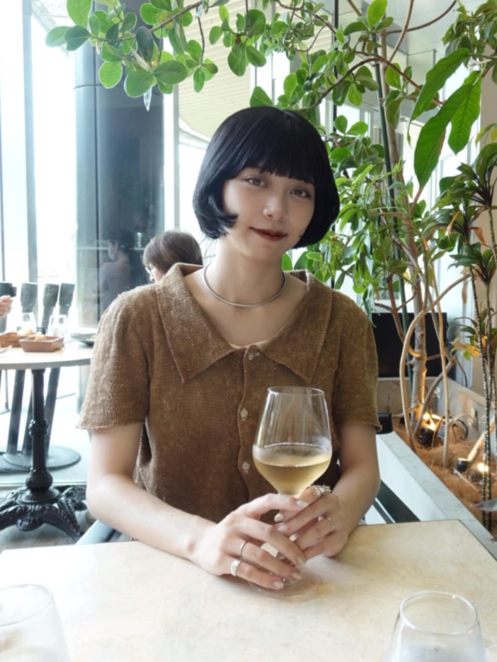 ホワイト系のスカート、ブラック系のパンプス、ブラウン系のトップスを着用したレディースの夏コーディネートの2枚目の写真