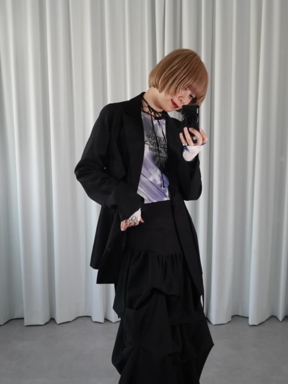 ブラック系のスカート、ブラック系のテーラードジャケット、ブルー系のTシャツ/カットソーを着用したレディースの春コーディネートの3枚目の写真