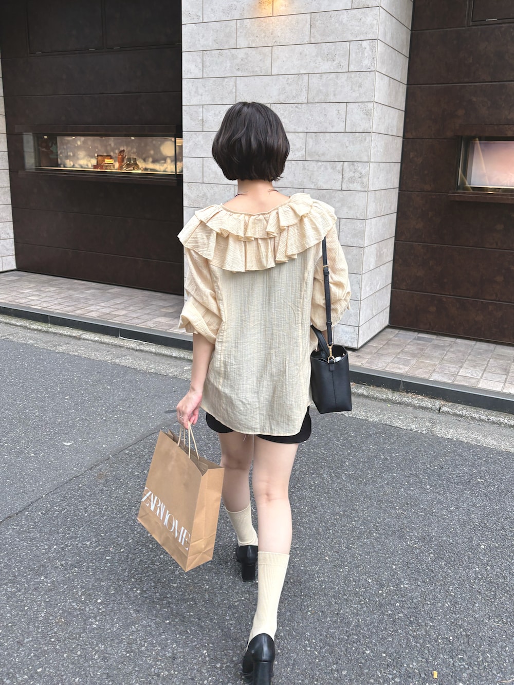 イエロー系のシャツ/ブラウス、ブラック系のスカート、ブラック系のローファーを着用したレディースの秋コーディネートの3枚目の写真