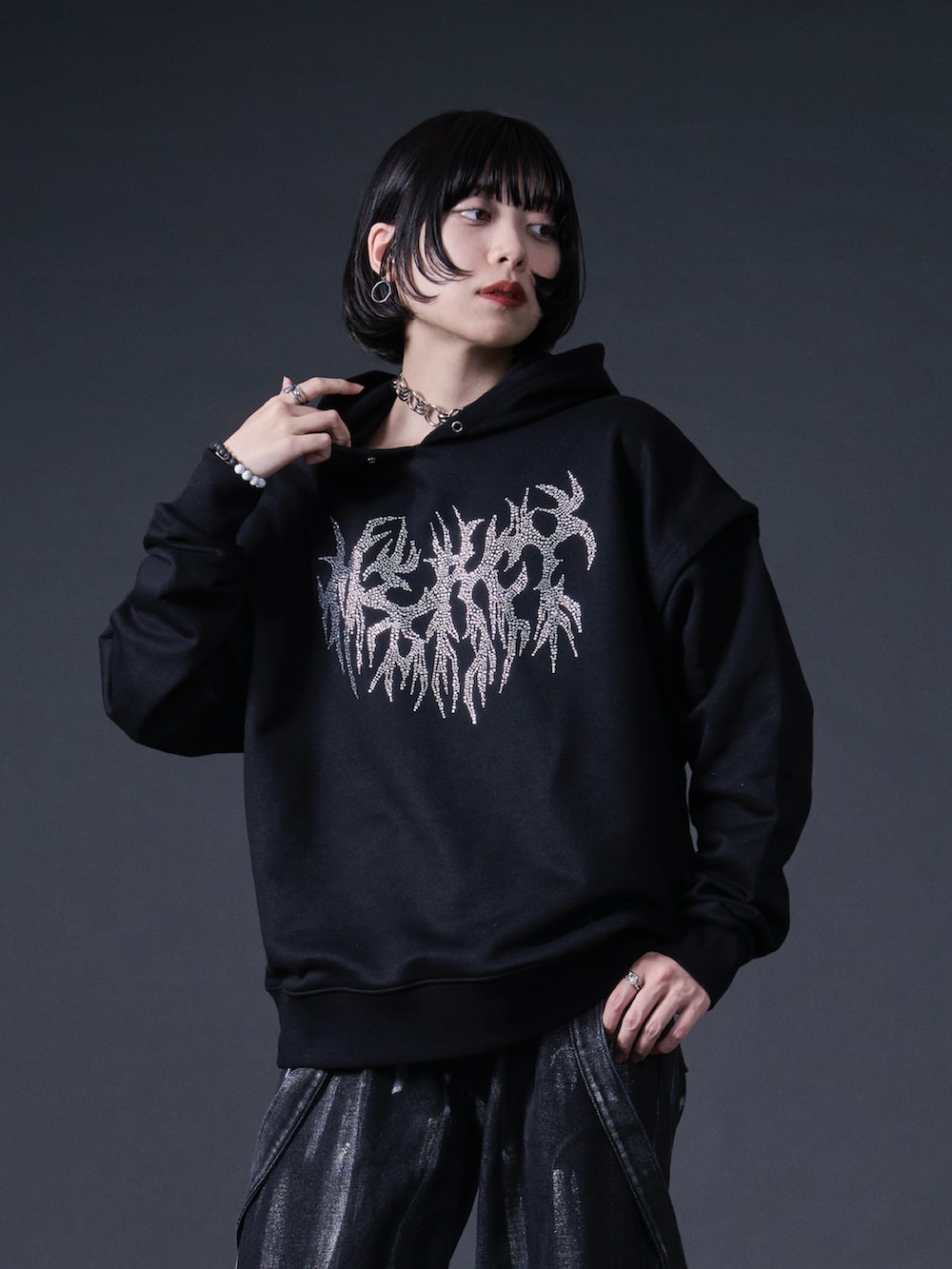 ブラック系のパーカー、ブラック系のデニムパンツ、ブラック系のローファーを着用したレディースの冬コーディネートの2枚目の写真