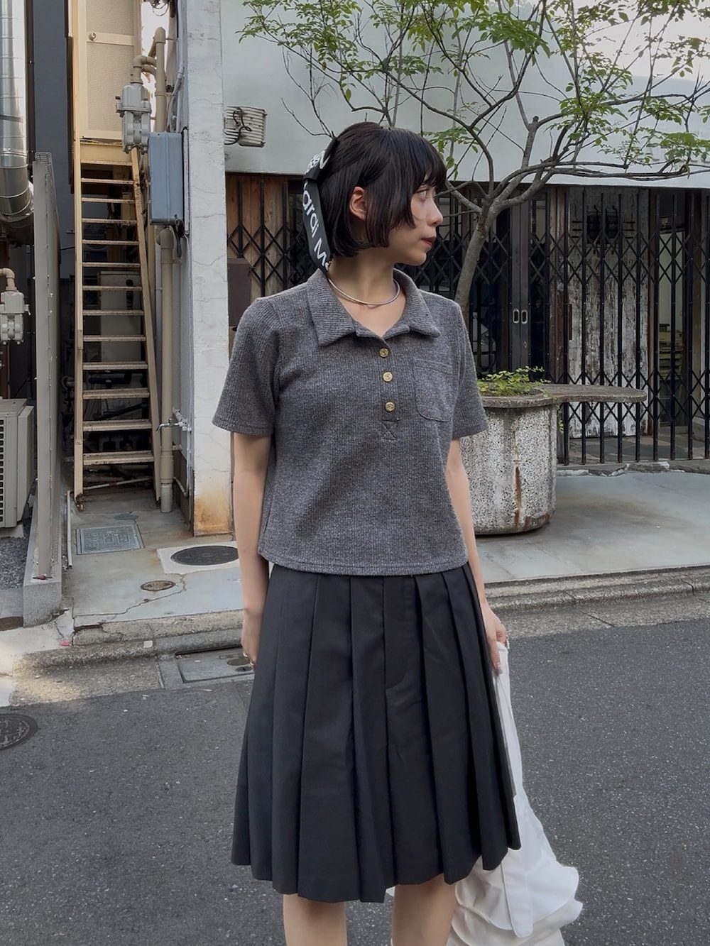 ブラック系のローファー、グレー系のスカート、グレー系のトップスを着用したレディースの秋コーディネートの2枚目の写真