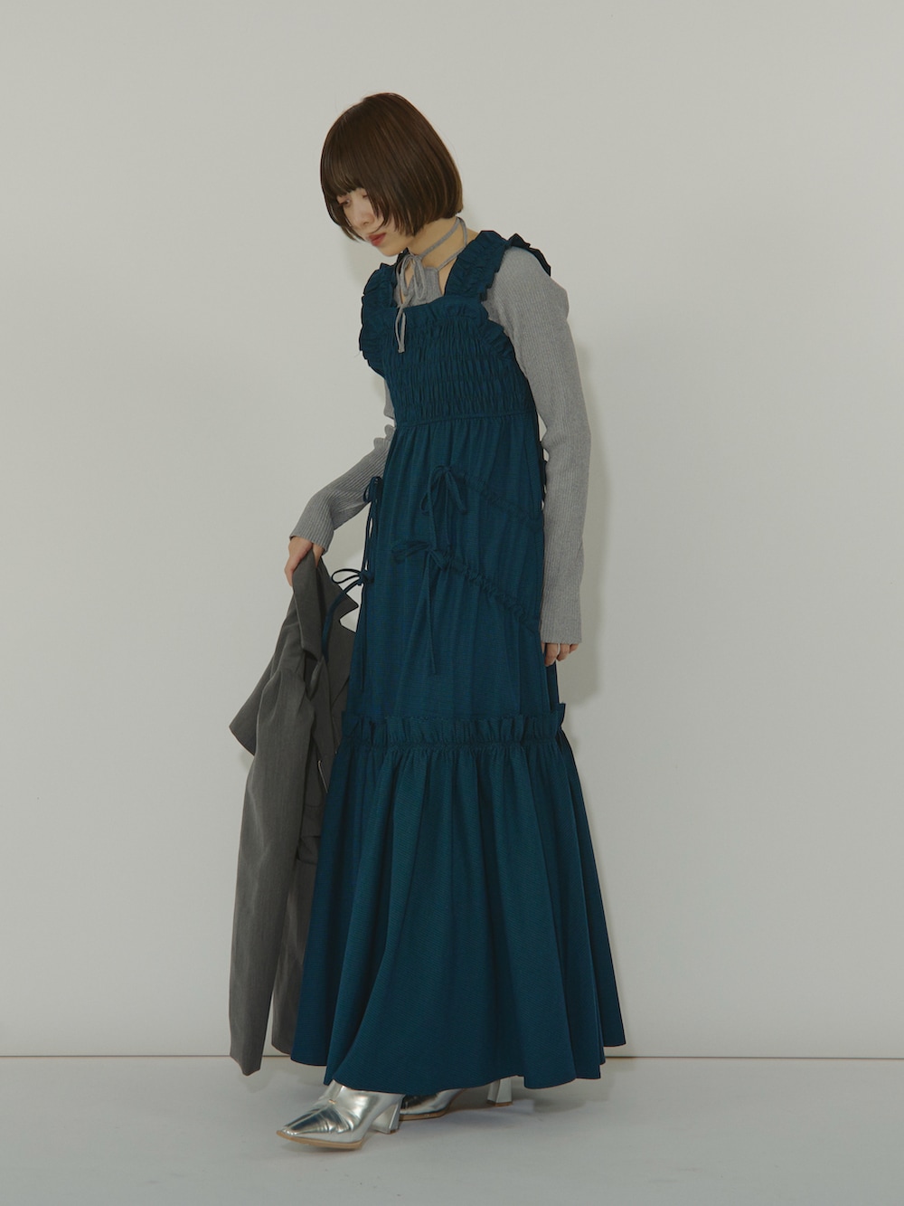 ブルー系のワンピース、ブラック系のテーラードジャケット、シルバー系のブーツを着用したレディースの冬コーディネートの4枚目の写真