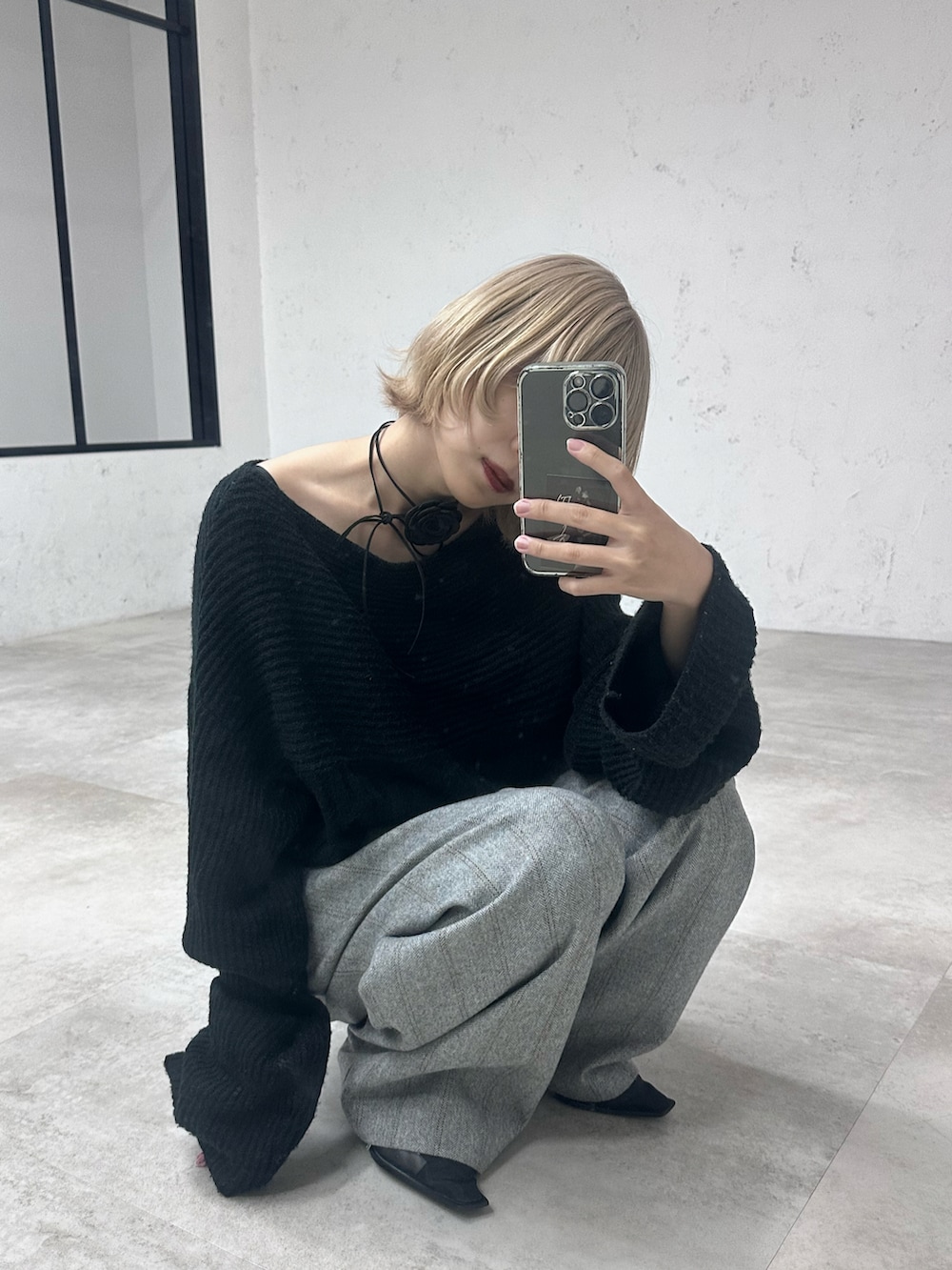 ブラック系のニット/セーター、グレー系のその他パンツ、ブラック系のパンプスを着用したレディースの春コーディネートの2枚目の写真