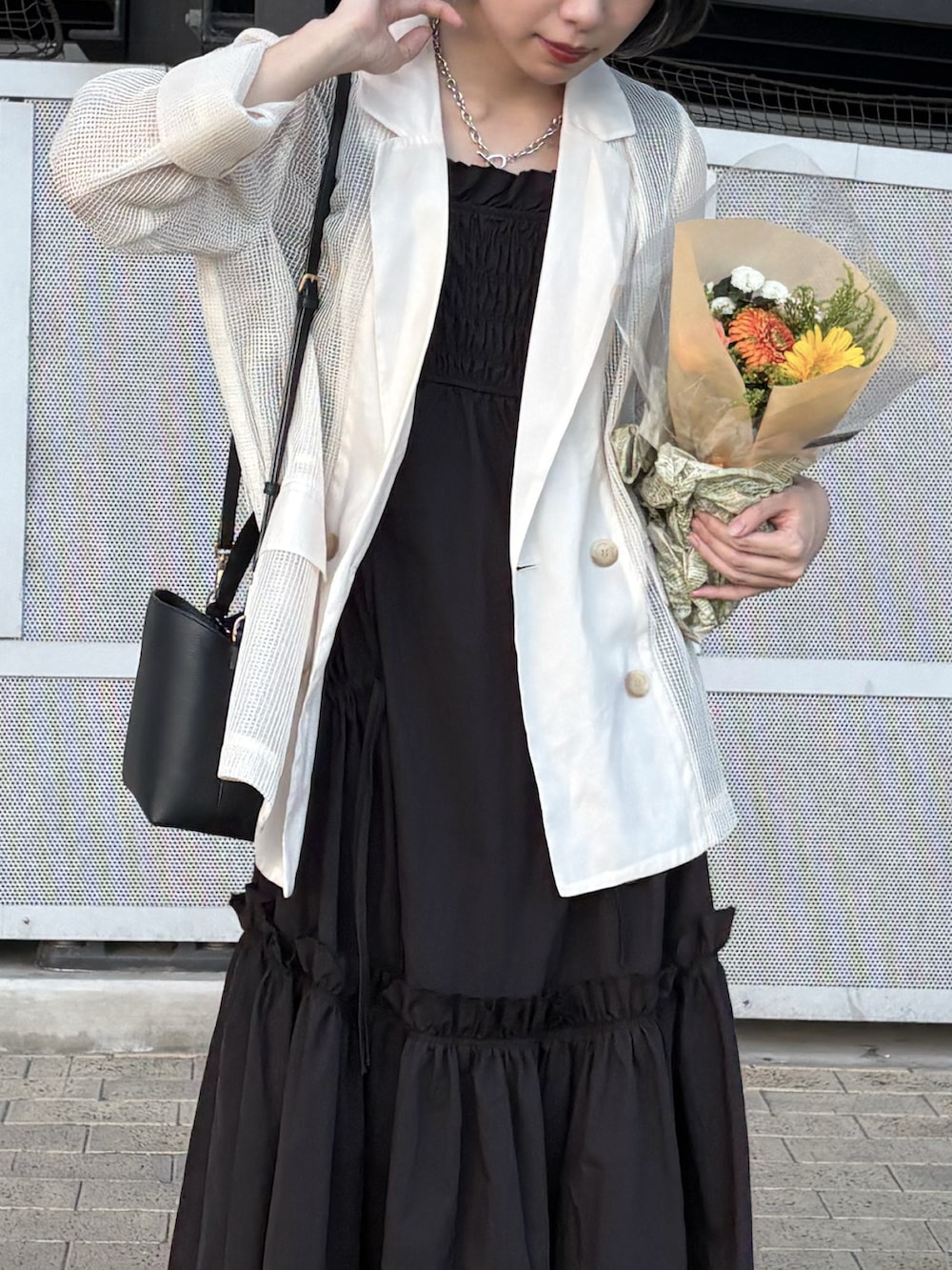 ブラック系のワンピース、ベージュ系のテーラードジャケット、ブラック系のショルダーバッグを着用したレディースの夏コーディネートの2枚目の写真