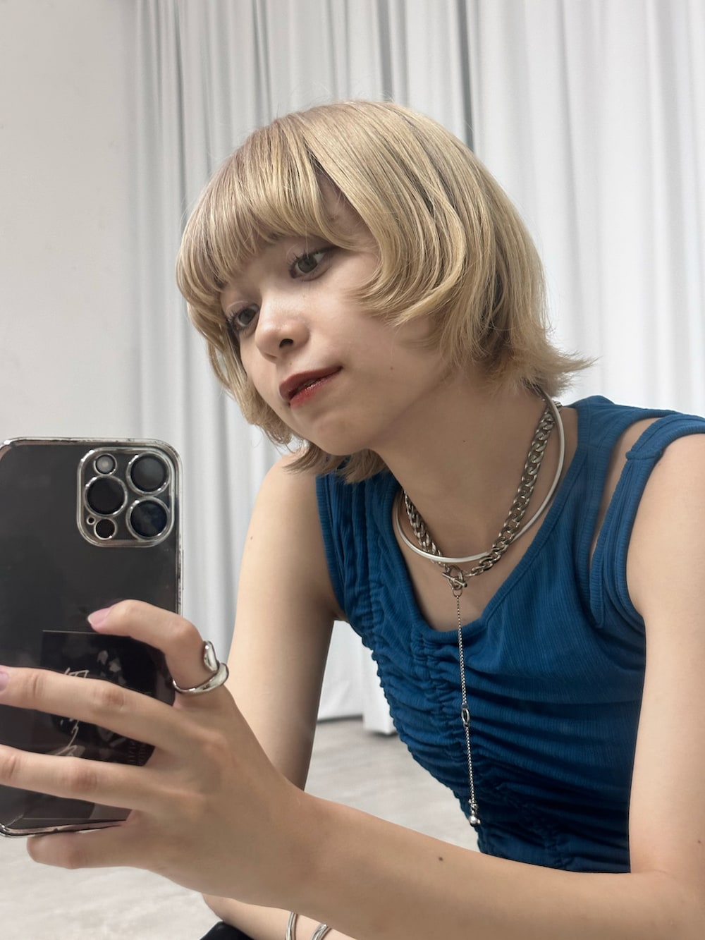 ブルー系のタンクトップ、ブラック系のスカート、ブラック系のパンプスを着用したレディースの春コーディネートの2枚目の写真