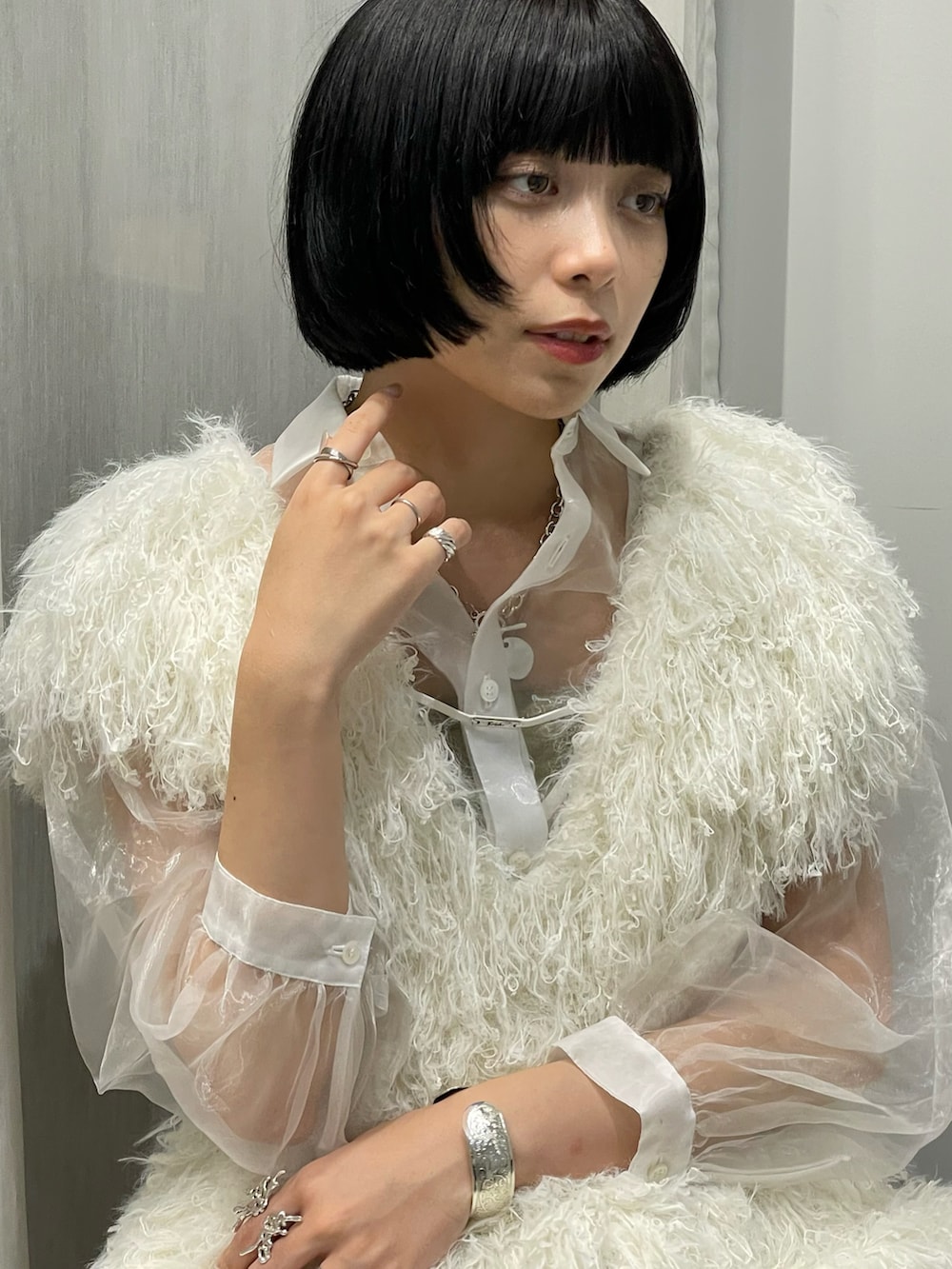 ホワイト系のベスト、ホワイト系のトップス、ブラウン系のパンツを着用したレディースの夏コーディネートの3枚目の写真