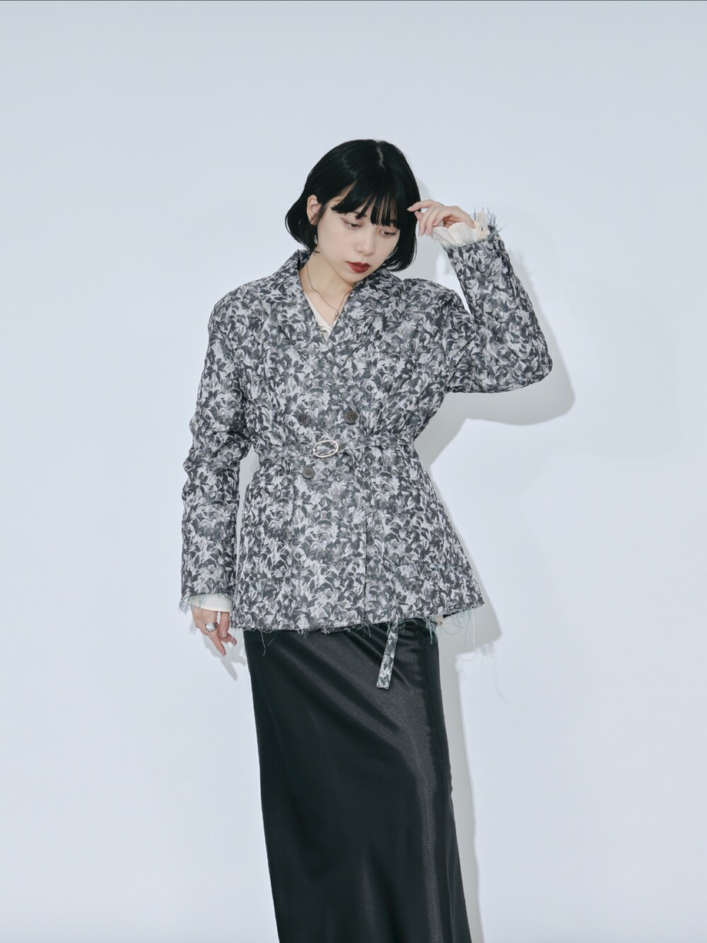 グレー系のテーラードジャケット、ブラック系のスカート、ホワイト系のシャツ/ブラウスを着用したレディースの冬コーディネートの2枚目の写真