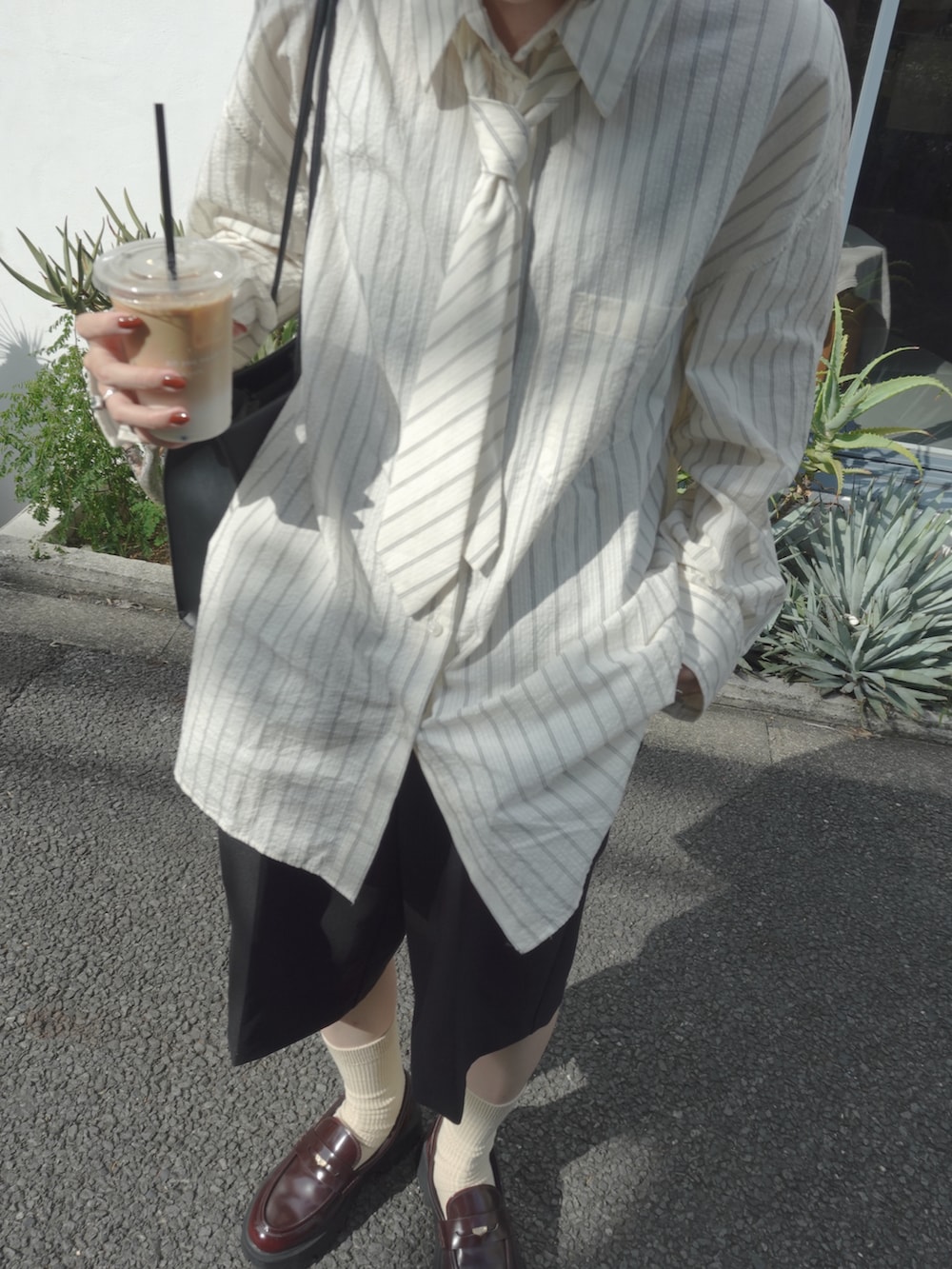 その他のローファー、ブラック系のパンツ、ブラック系のショルダーバッグを着用したレディースの秋コーディネートの4枚目の写真