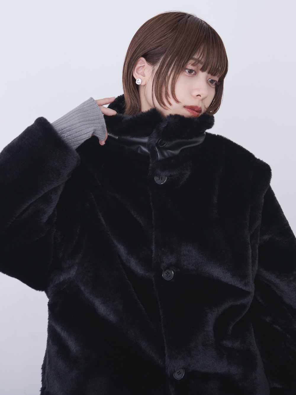 ブラック系のブルゾン、グレー系のニット/セーター、ブラック系のデニムパンツを着用したレディースの冬コーディネートの2枚目の写真