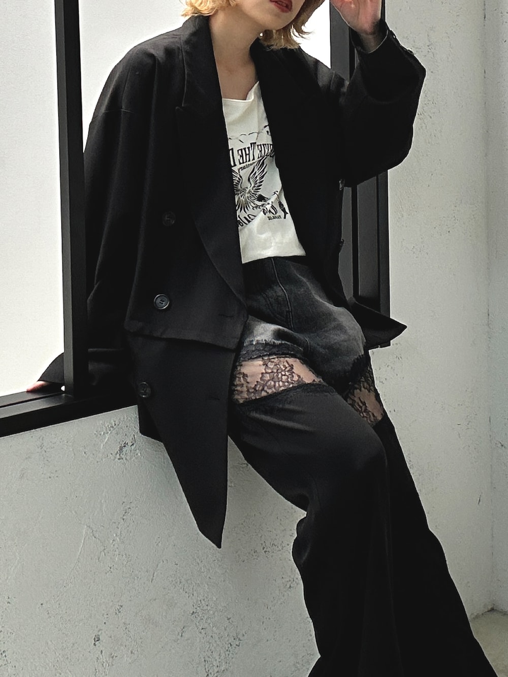 ブラック系のデニムパンツ、ホワイト系のトップス、ブラック系のテーラードジャケットを着用したレディースの春コーディネートの2枚目の写真