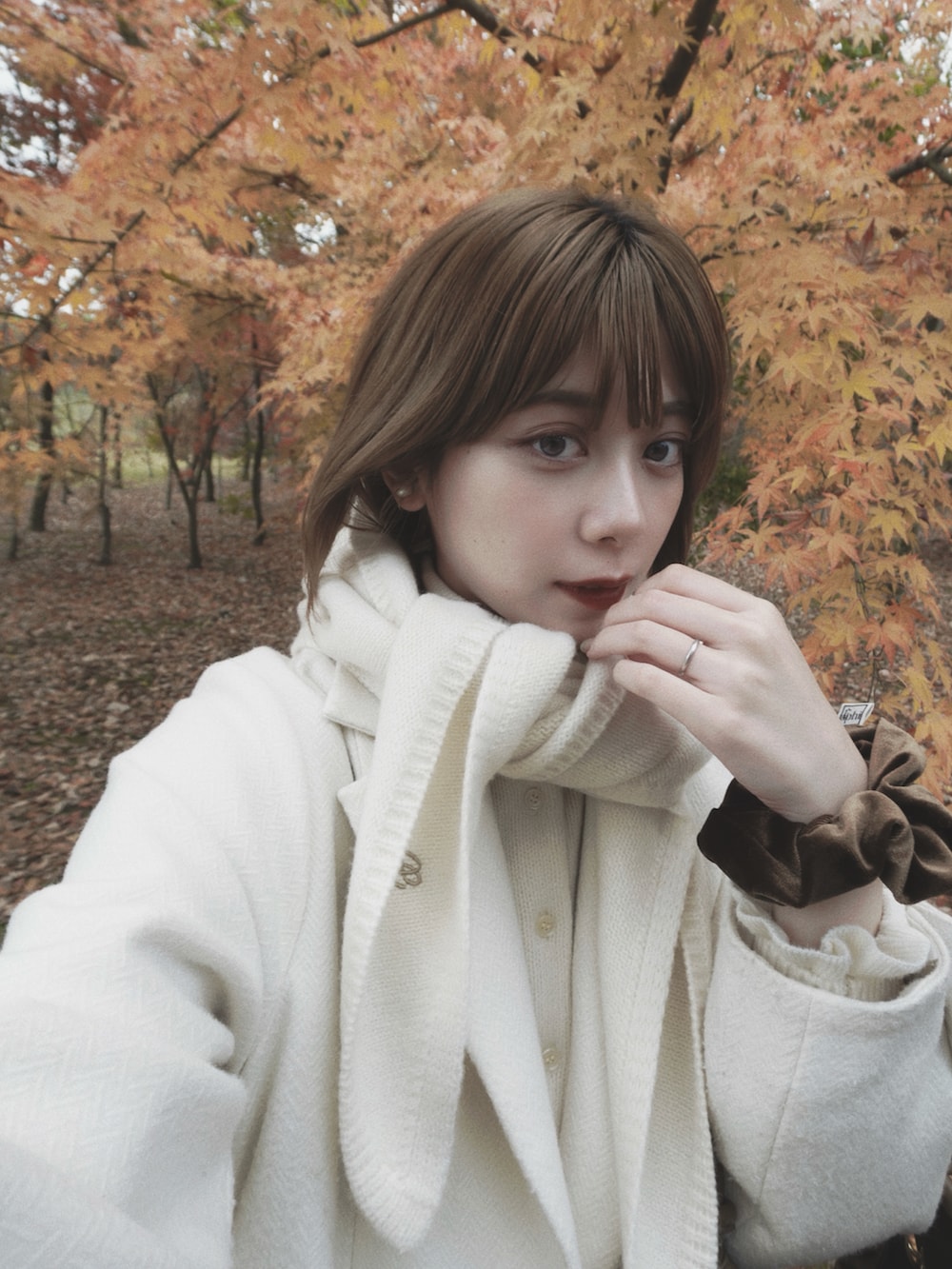 グリーン系のバレエシューズ、グレー系のニット/セーター、ホワイト系のジャケット/アウターを着用したレディースの秋コーディネートの2枚目の写真