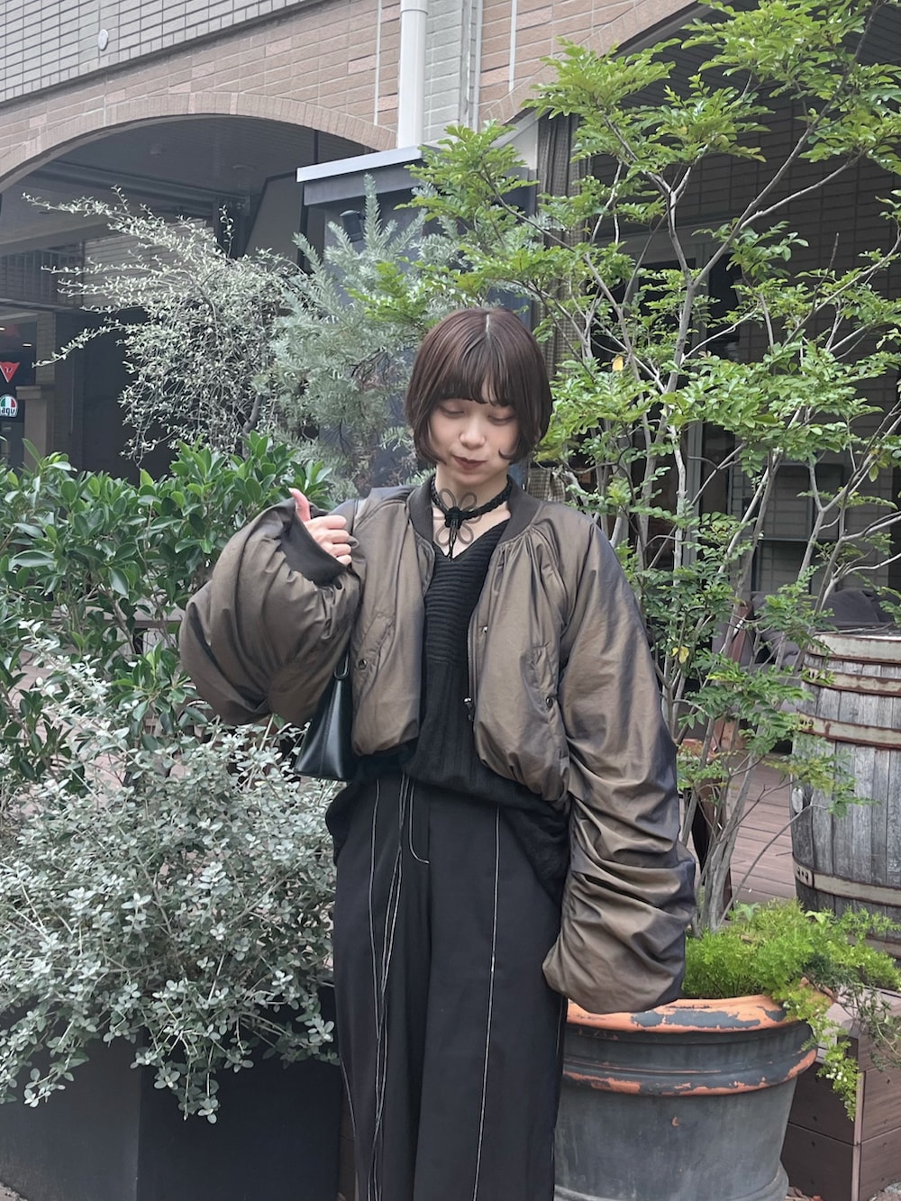 ブラック系のニット/セーター、ブラウン系のMA-1、ブラック系のスラックスを着用したレディースの秋コーディネートの2枚目の写真