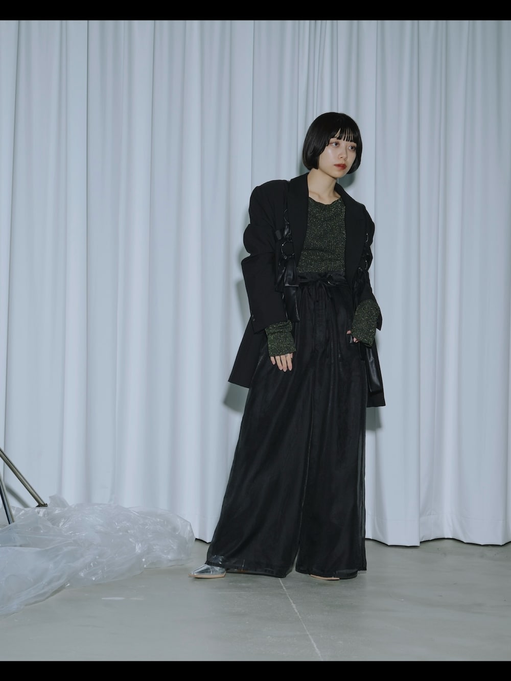 グリーン系のニット/セーター、ブラック系のテーラードジャケット、ブラック系のその他パンツを着用したレディースの春コーディネートの3枚目の写真