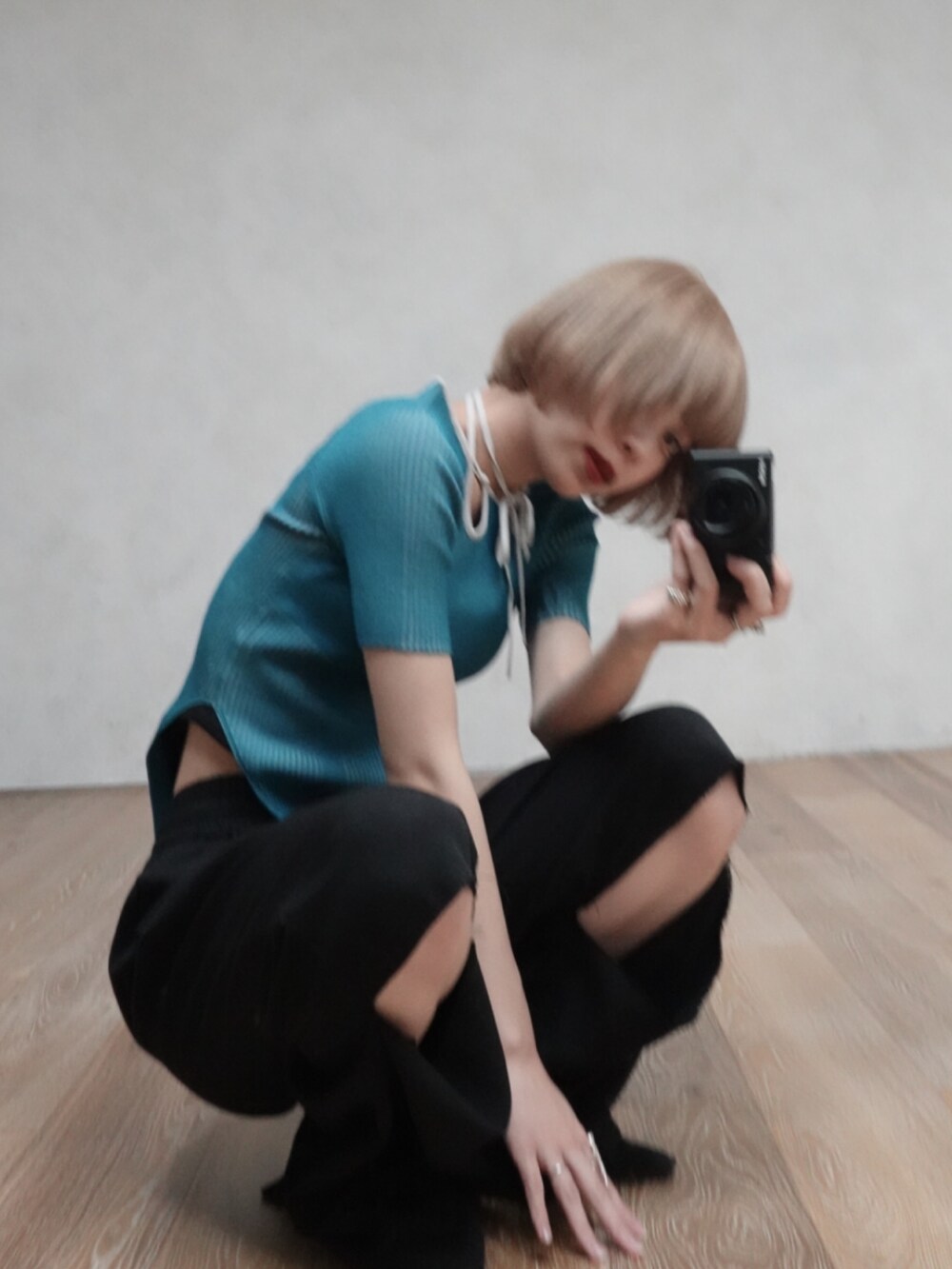 ブルー系のニット/セーター、ブラック系のスラックスを着用したレディースの春コーディネートの2枚目の写真