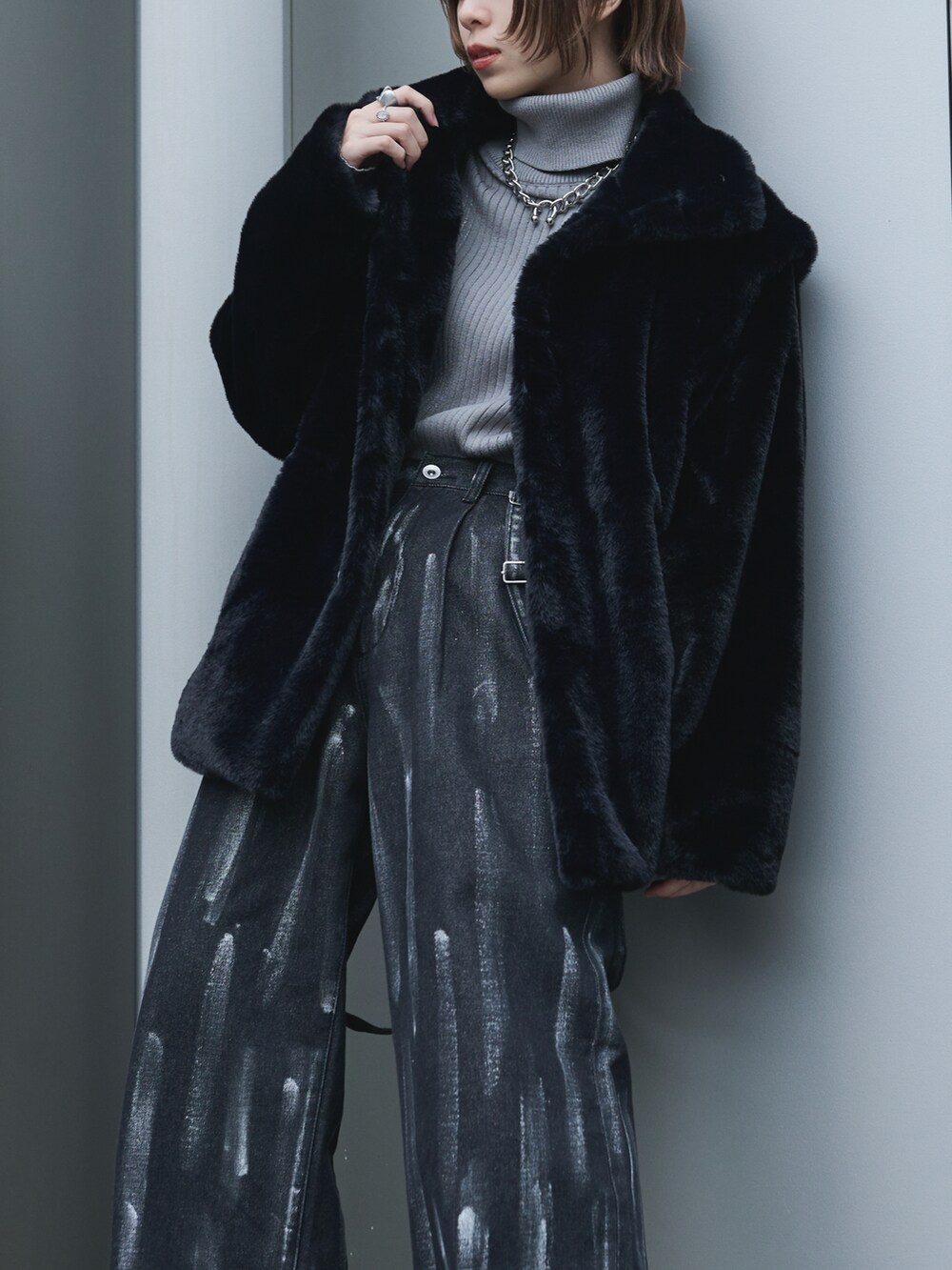 ブラック系のブルゾン、グレー系のニット/セーター、ブラック系のデニムパンツを着用したレディースの冬コーディネートの2枚目の写真