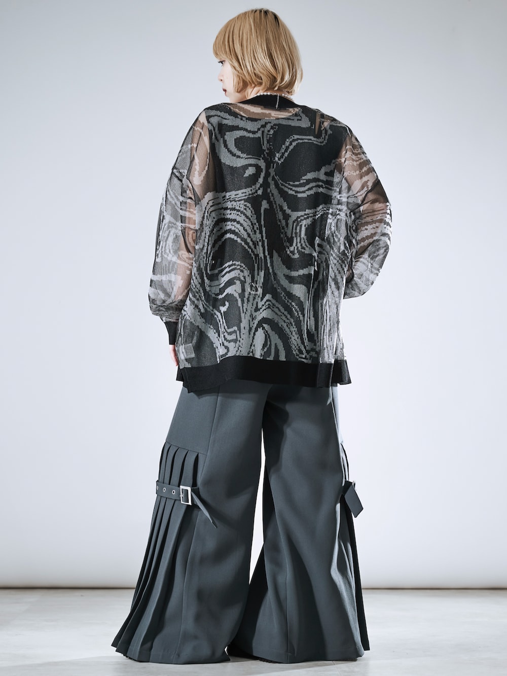 グレー系のその他パンツ、ブラック系のカーディガン/ボレロ、シルバー系のネックレスを着用したレディースの春コーディネートの5枚目の写真