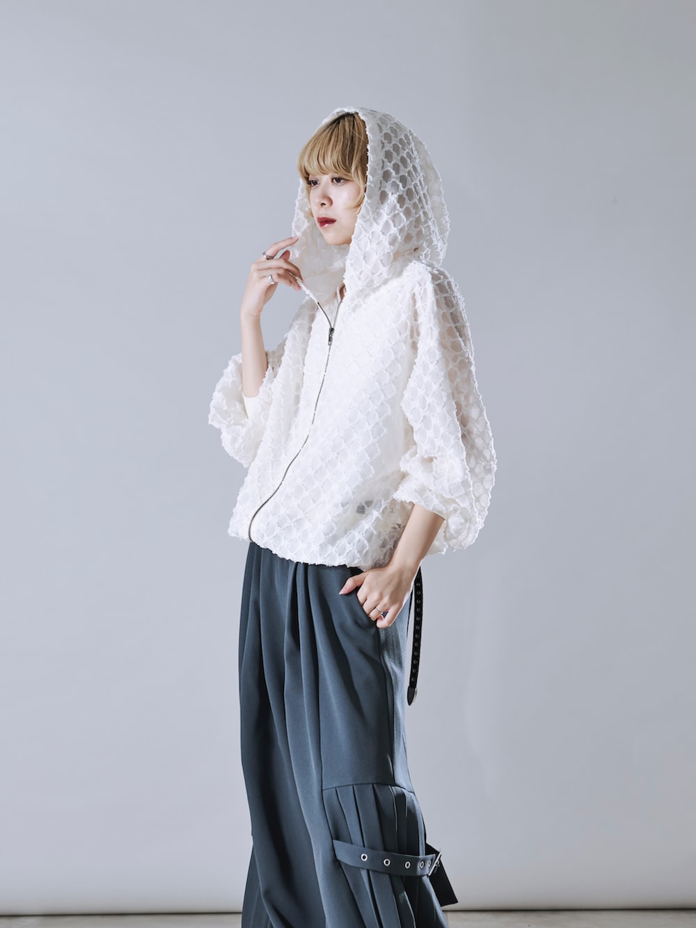 ホワイト系のブルゾン、グレー系のその他パンツを着用したレディースの春コーディネートの2枚目の写真