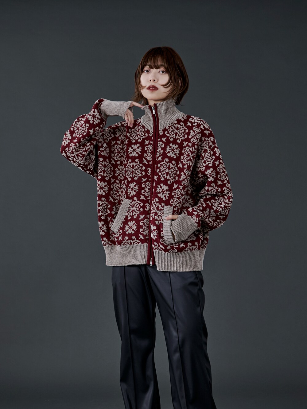 レッド系のニット/セーター、ブラック系のスラックス、ブラック系のブーツを着用したレディースの冬コーディネートの4枚目の写真