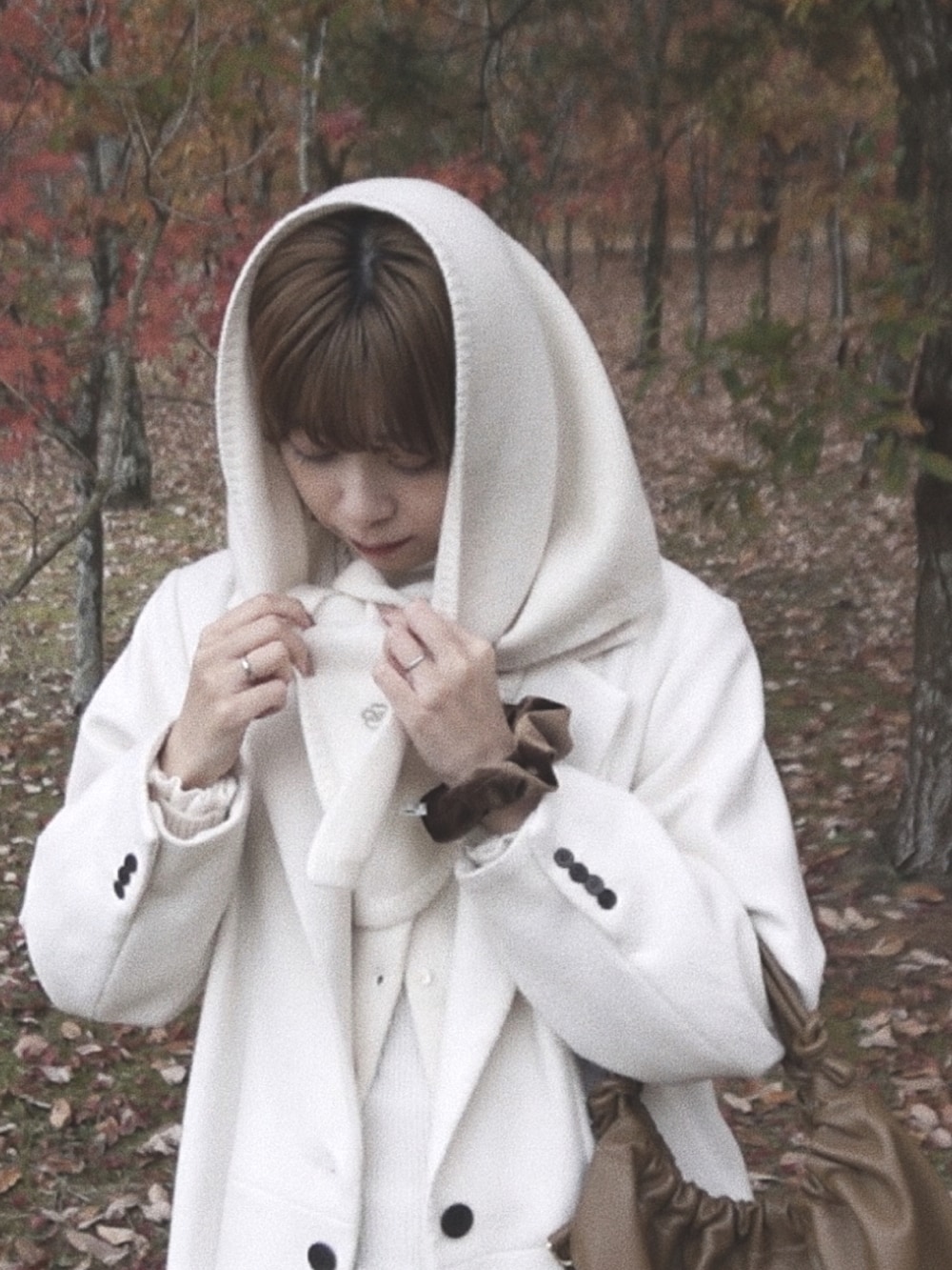 グリーン系のバレエシューズ、グレー系のニット/セーター、ホワイト系のジャケット/アウターを着用したレディースの秋コーディネートの4枚目の写真