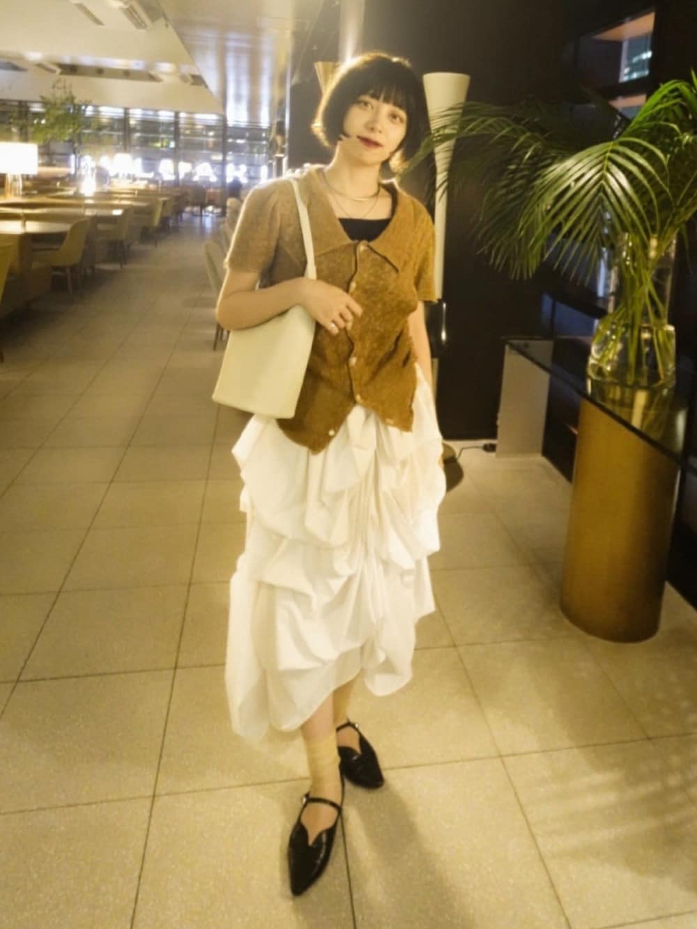 ホワイト系のスカート、ブラック系のパンプス、ブラウン系のトップスを着用したレディースの夏コーディネートの3枚目の写真