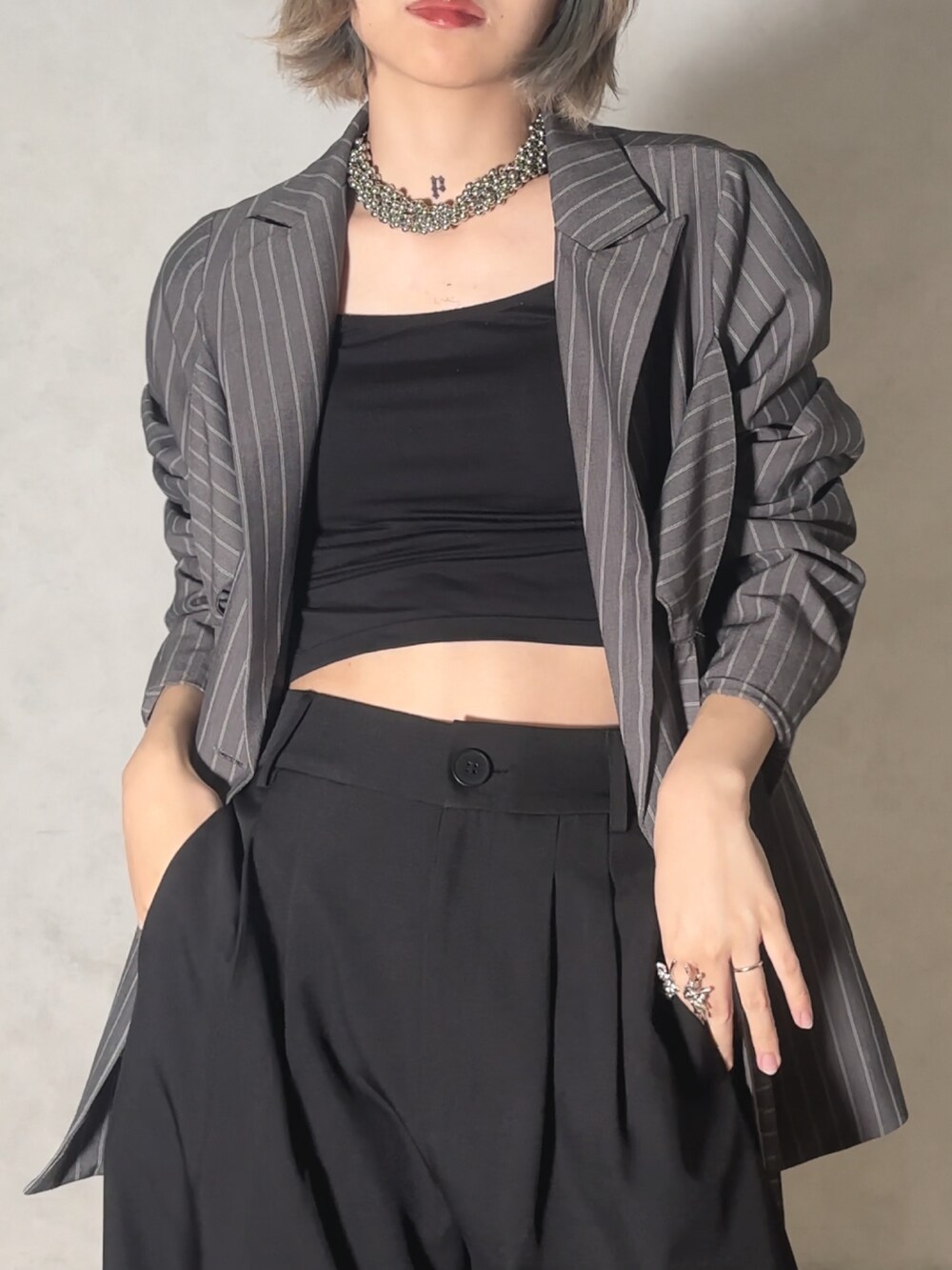 グレー系のテーラードジャケット、ブラック系のスラックスを着用したレディースの夏コーディネートの2枚目の写真