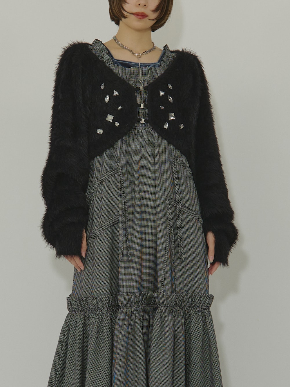 ブルー系のワンピース、ブラック系のカーディガン/ボレロ、シルバー系のブーツを着用したレディースの冬コーディネートの2枚目の写真