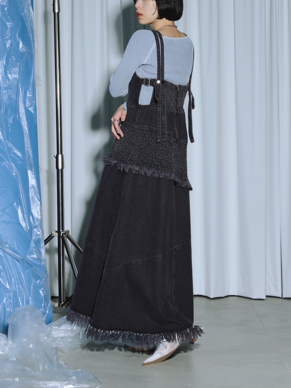 ブラック系のワンピース、ブルー系のニット/セーター、シルバー系のパンプスを着用したレディースの春コーディネートの2枚目の写真