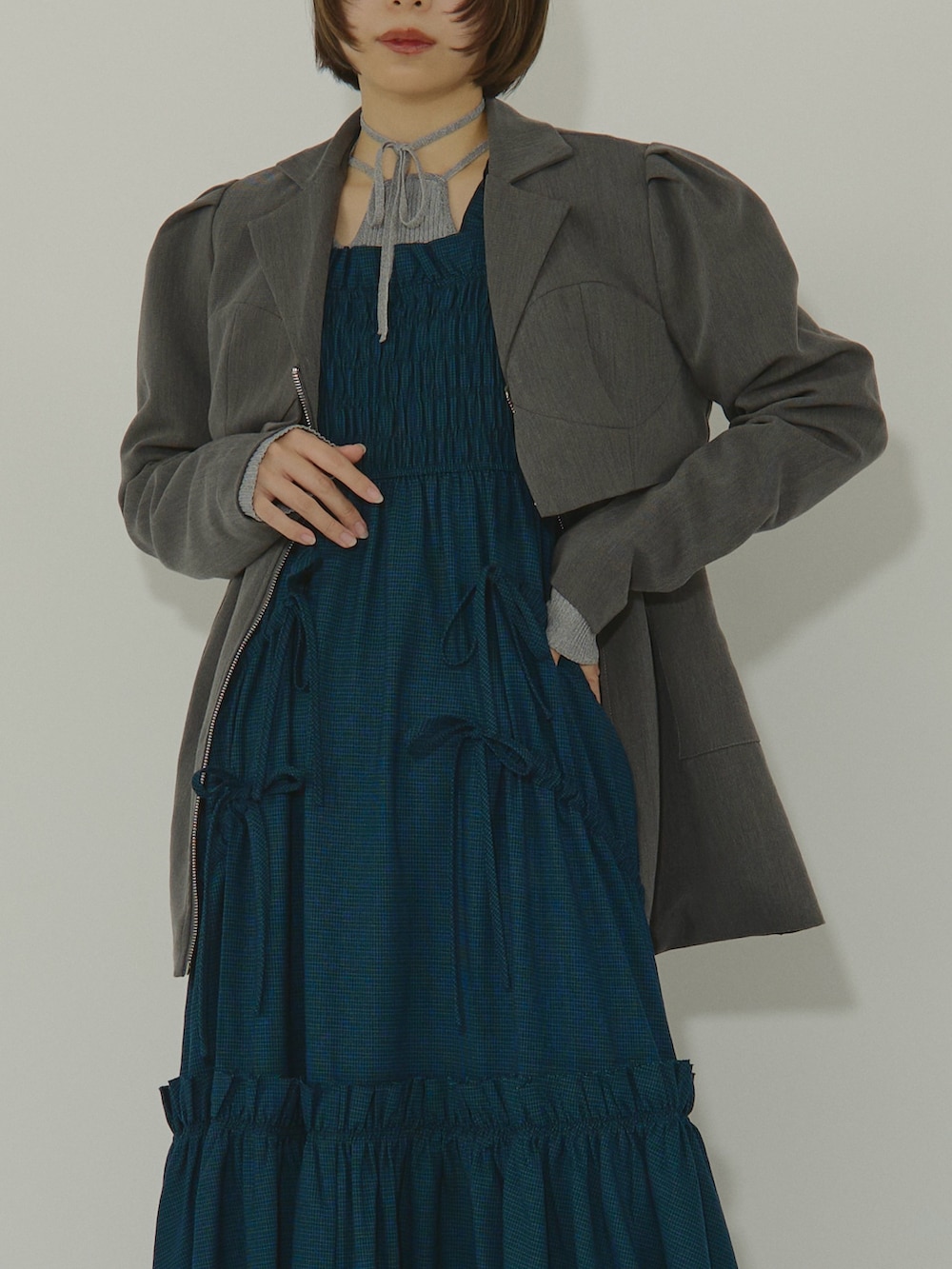 ブルー系のワンピース、ブラック系のテーラードジャケット、シルバー系のブーツを着用したレディースの冬コーディネートの5枚目の写真