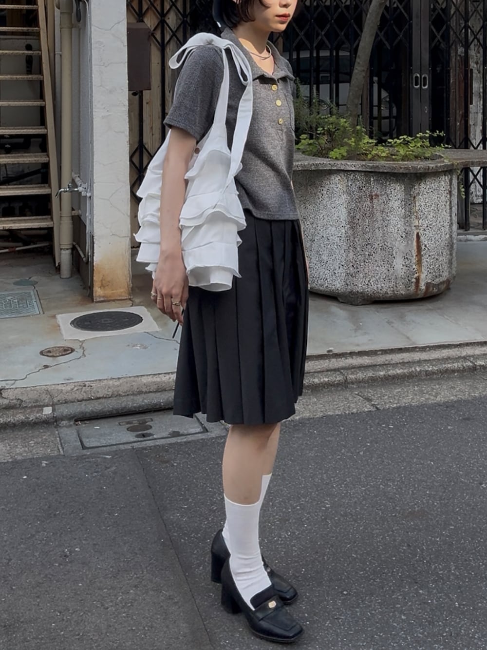 ブラック系のローファー、グレー系のスカート、グレー系のトップスを着用したレディースの秋コーディネートの3枚目の写真