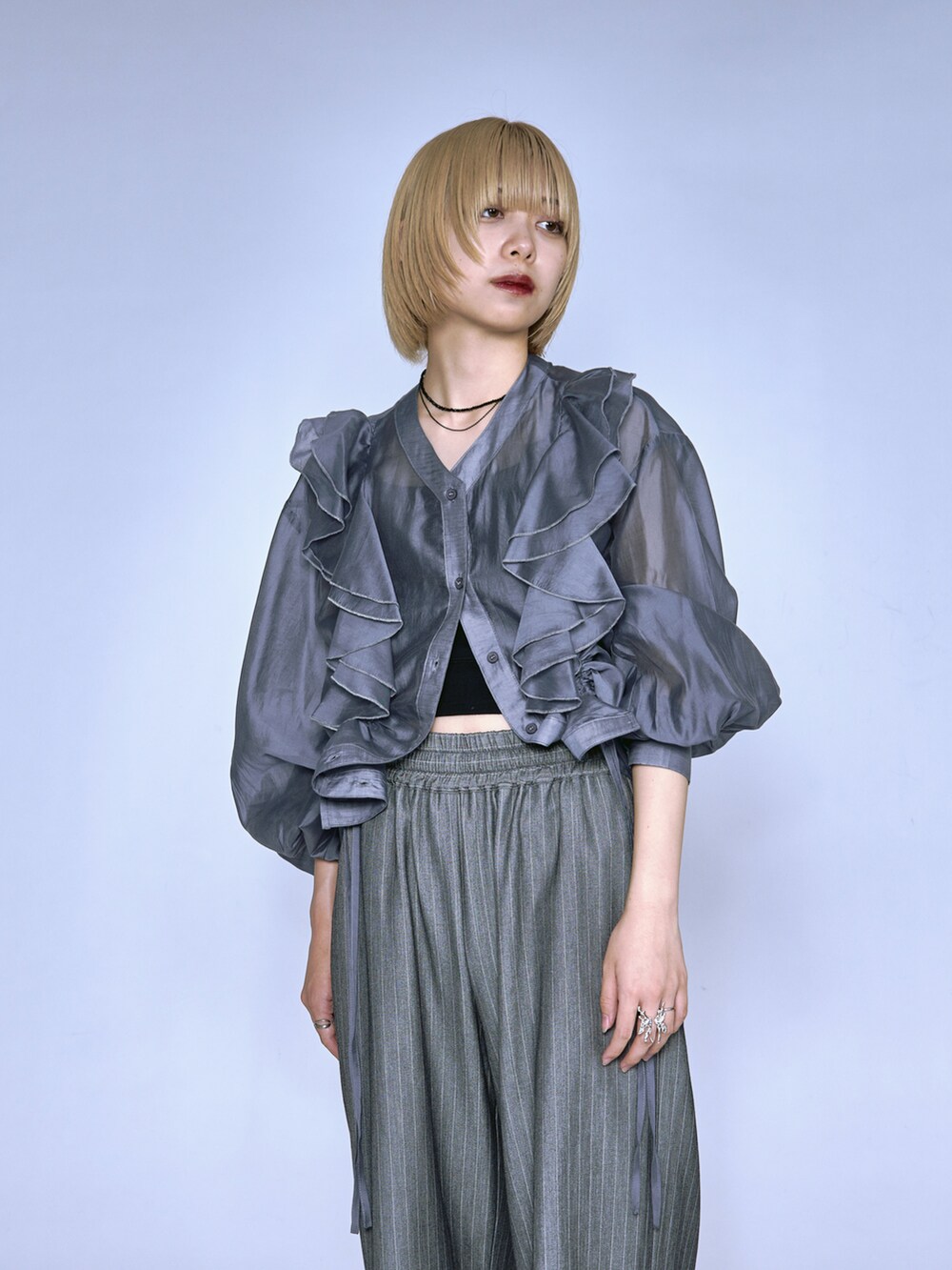 ブルー系のシャツ/ブラウス、グレー系のスラックスを着用したレディースの春コーディネートの2枚目の写真