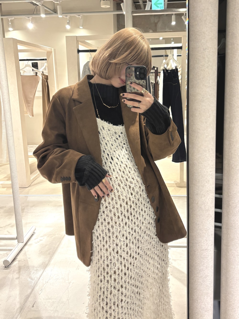 ブラウン系のテーラードジャケット、ブラウン系のデニムパンツ、ベージュ系のワンピース/ドレスを着用したレディースの冬コーディネートの5枚目の写真