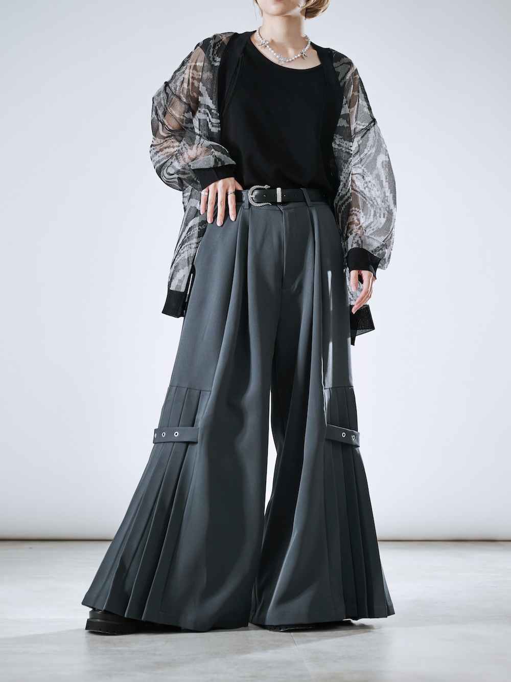 グレー系のその他パンツ、ブラック系のカーディガン/ボレロ、シルバー系のネックレスを着用したレディースの春コーディネートの2枚目の写真