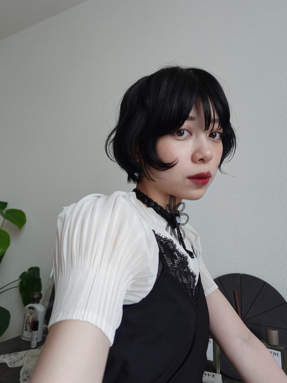 ブラック系のパンプス、ブラック系のワンピース、ホワイト系のトップスを着用したレディースの夏コーディネートの5枚目の写真
