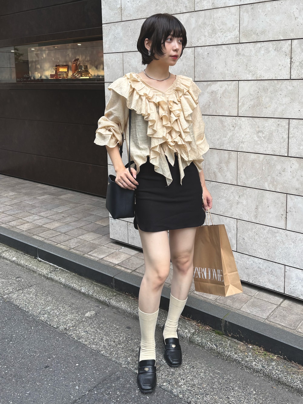 イエロー系のシャツ/ブラウス、ブラック系のスカート、ブラック系のローファーを着用したレディースの秋コーディネートの2枚目の写真